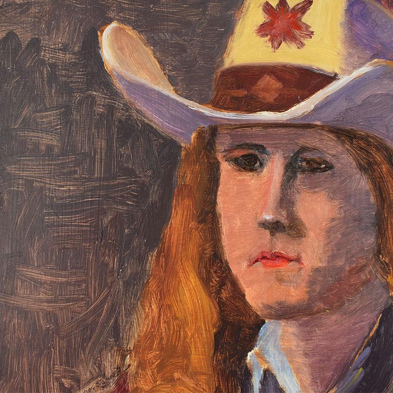 A small figural portrait painting on board of a cowgirl. The subject of this piece wears a cream color western cowboy hat decorated with a red star. She has long reddish hair and wears a blue long sleeve shirt and handkerchief tied at the front. The