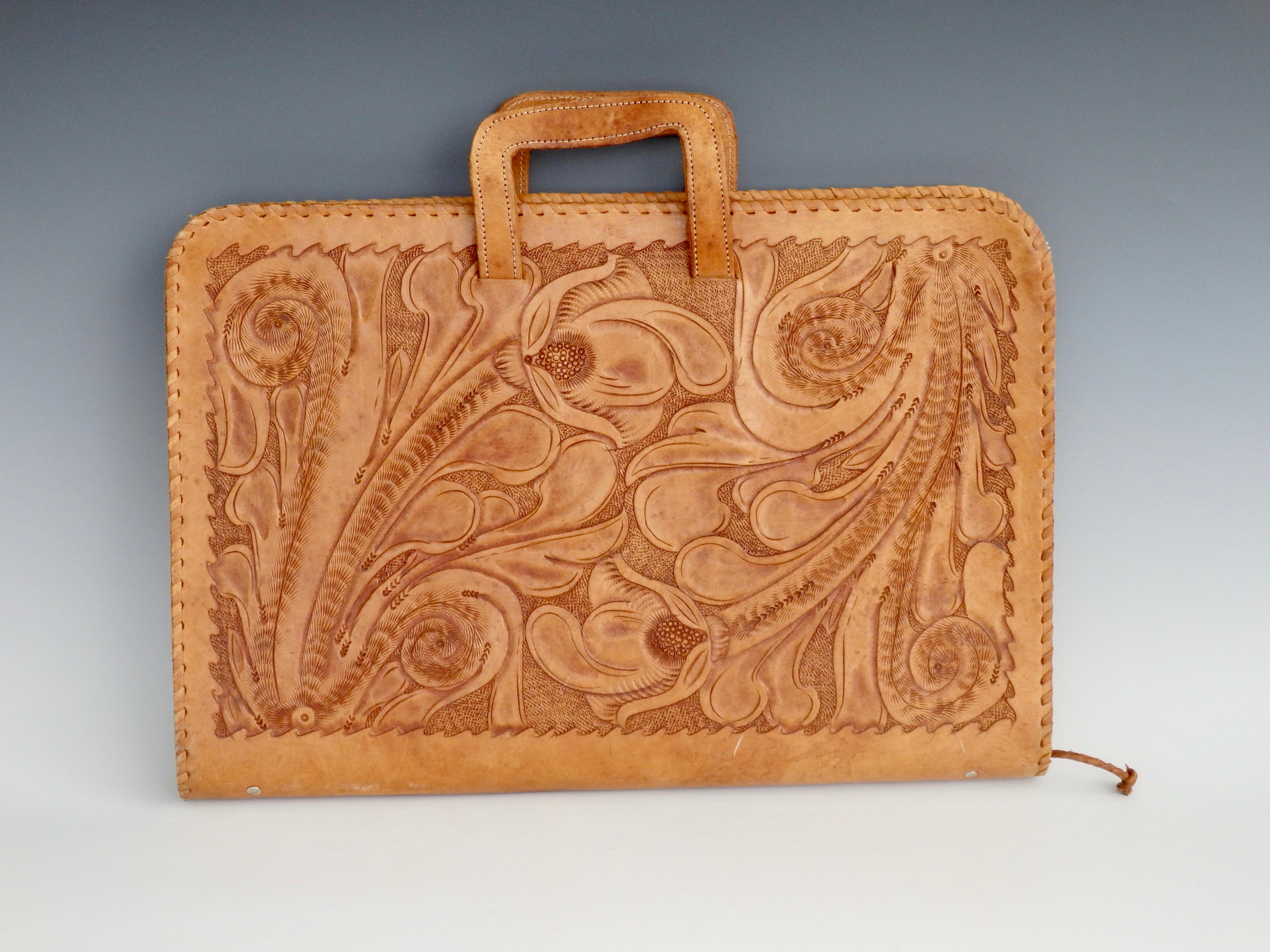 Beautiful hand tooled leather attache case with whipstitch detail, retractable handles and full outer zipper closure. The interior has two interior pockets and one zippered compartment.