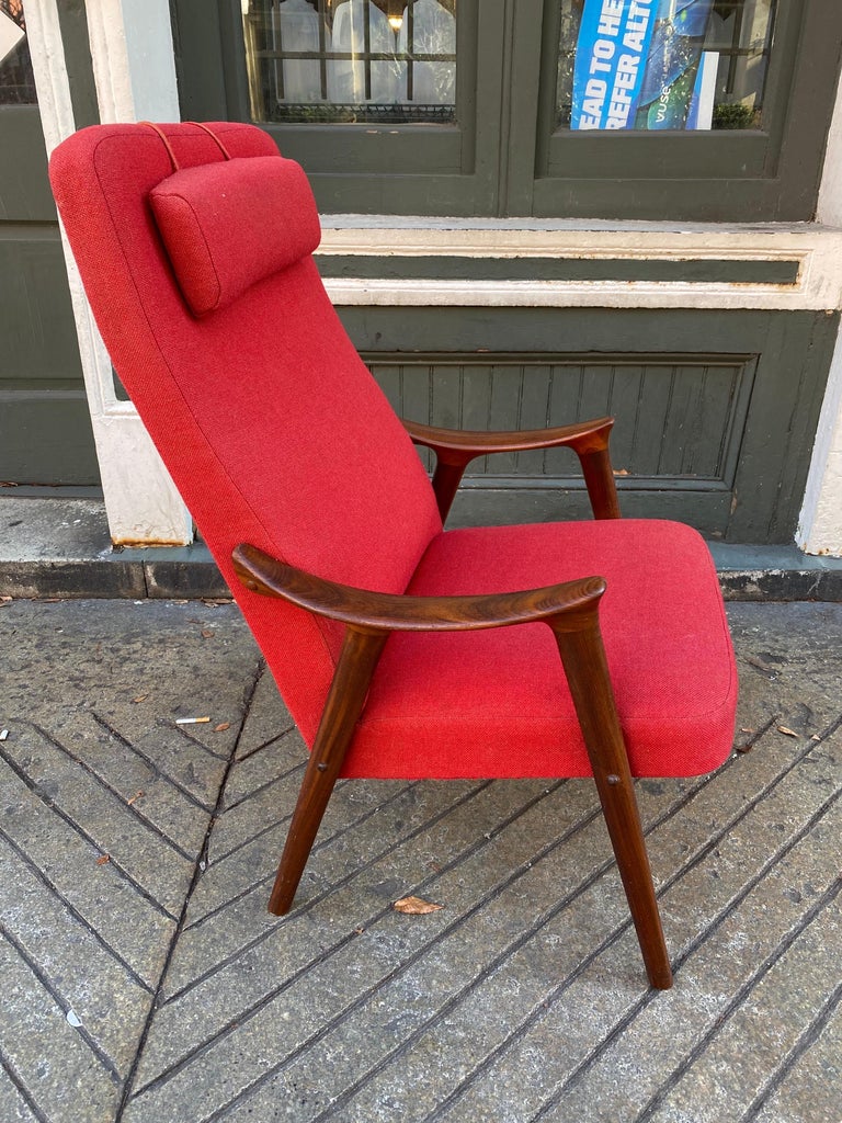 A stylish teak lounge chair from the 1960s designed by Ingmar Relling for Westnofa of Norway. Gorgeous Scandinavian Modern era lines with a solid teak frame with paddle-style armrests and a detachable headrest. The red upholstery complements the