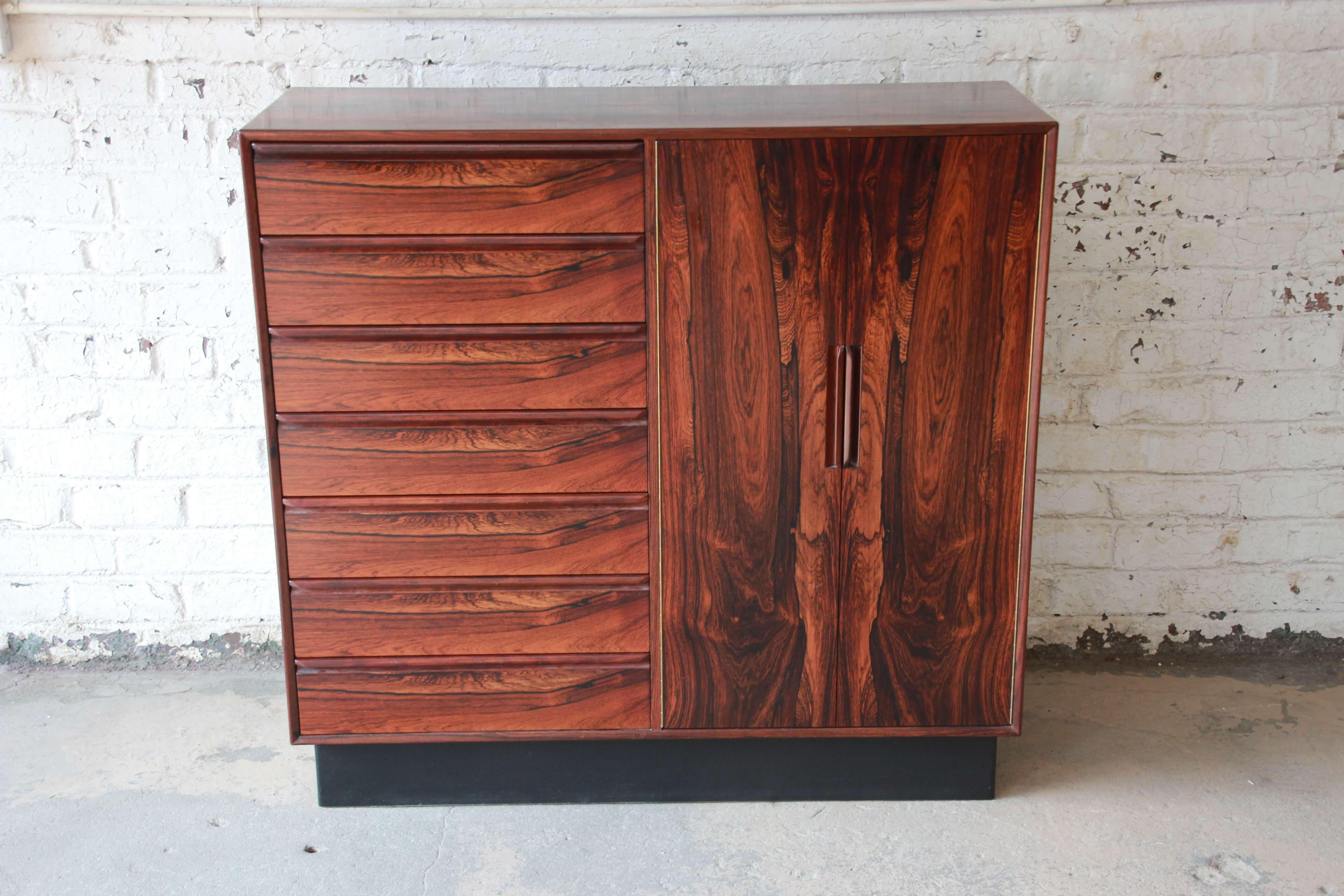 Offering a stunning Norwegian rosewood gentlemen's chest or dresser by Westnofa. This statement piece has a rich and vibrant wood grain throughout the entire piece. The two cabinet doors on the right open up to reveal seven graduated drawers for