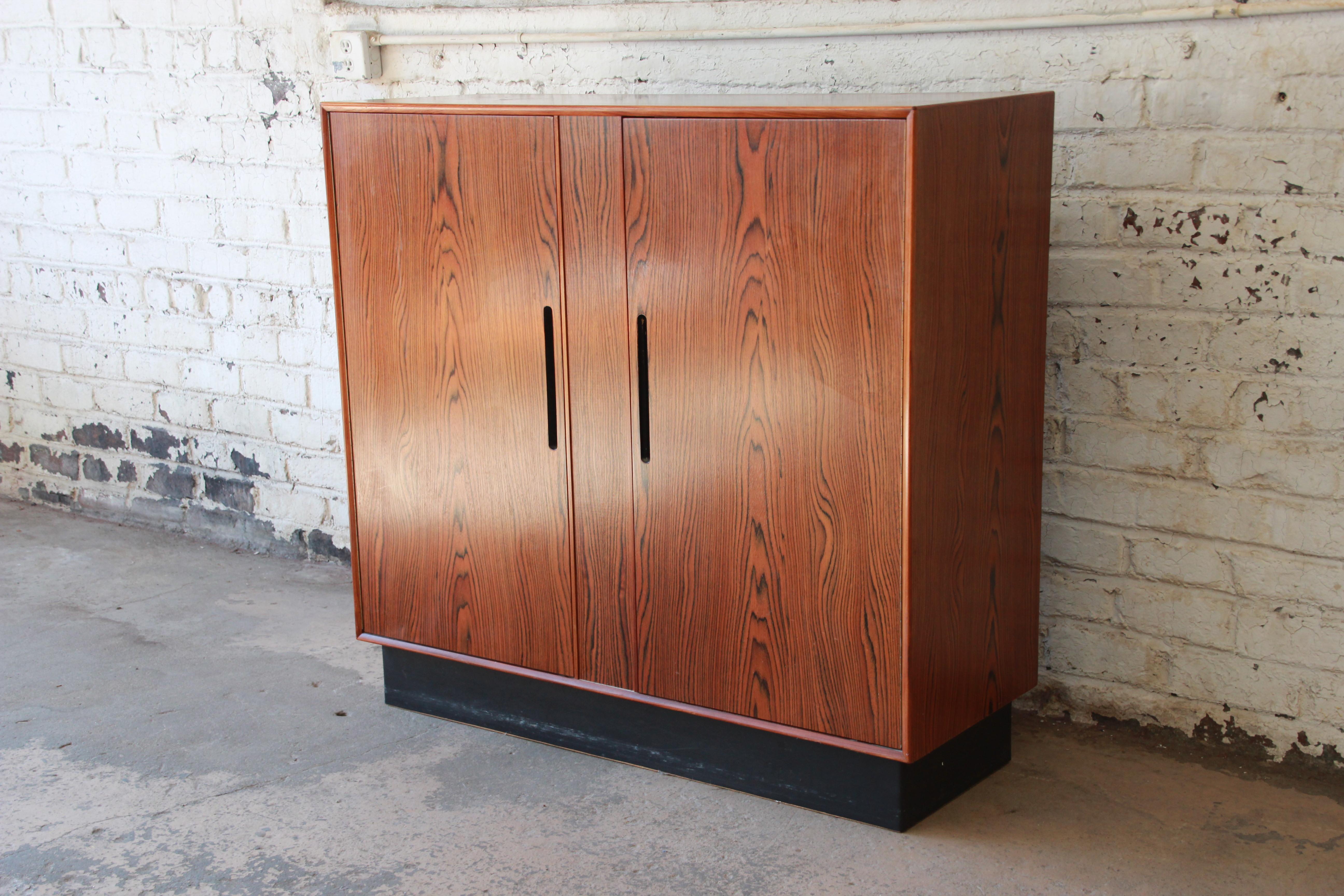 A gorgeous Scandinavian Modern rosewood gentleman's chest or dresser by Westnofa. The chest features stunning wood grain and sleek Scandinavian design. It offers ample room for storage, with six dovetailed drawers behind the left door and three