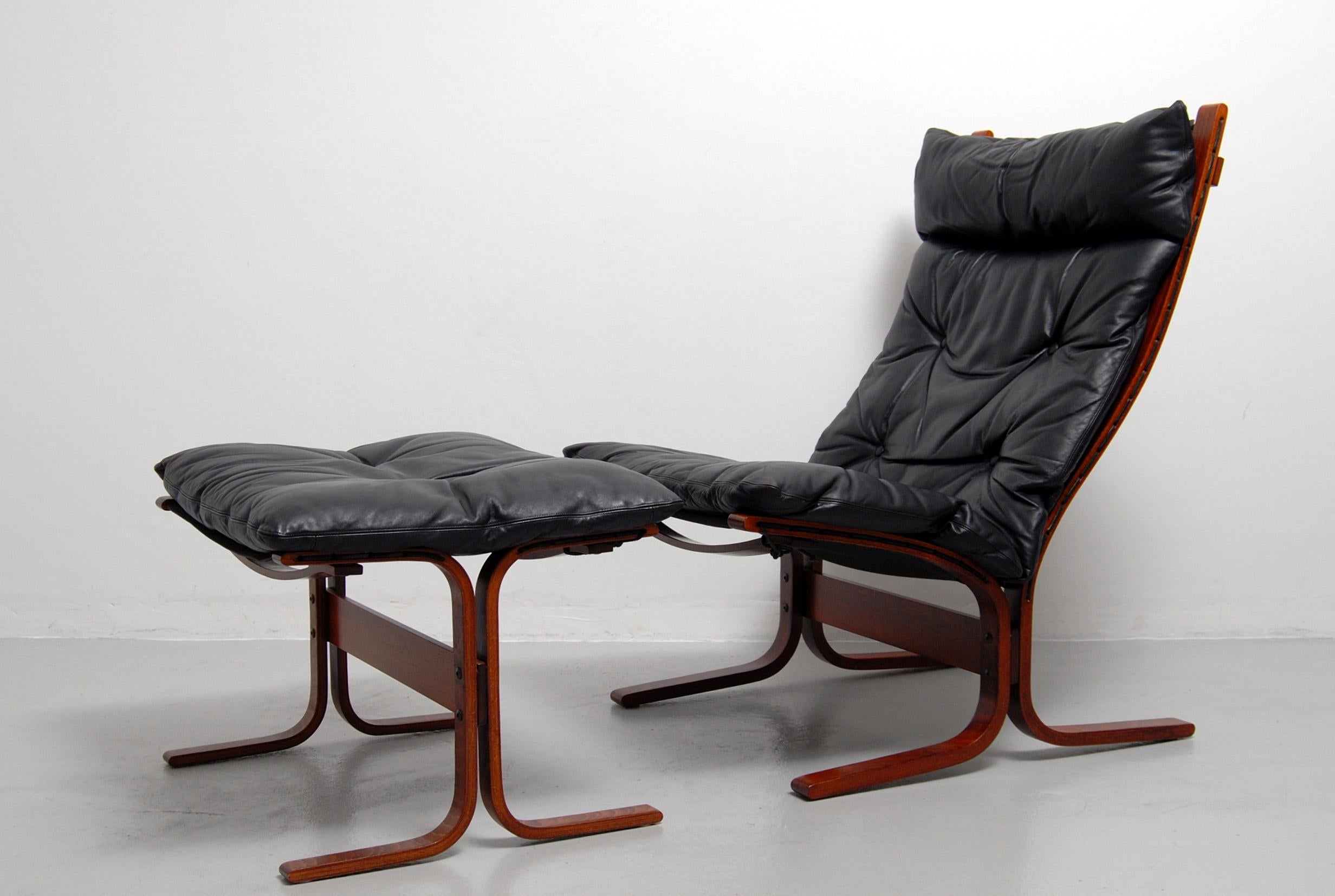 Siesta high back lounge chair and matching ottoman designed by Ingmar Relling and made in Norway by Westnofa. This award winning chair and ottoman has a bentwood frame with a black leather cushion that sits on a canvas sling. Labelled with Westnofa