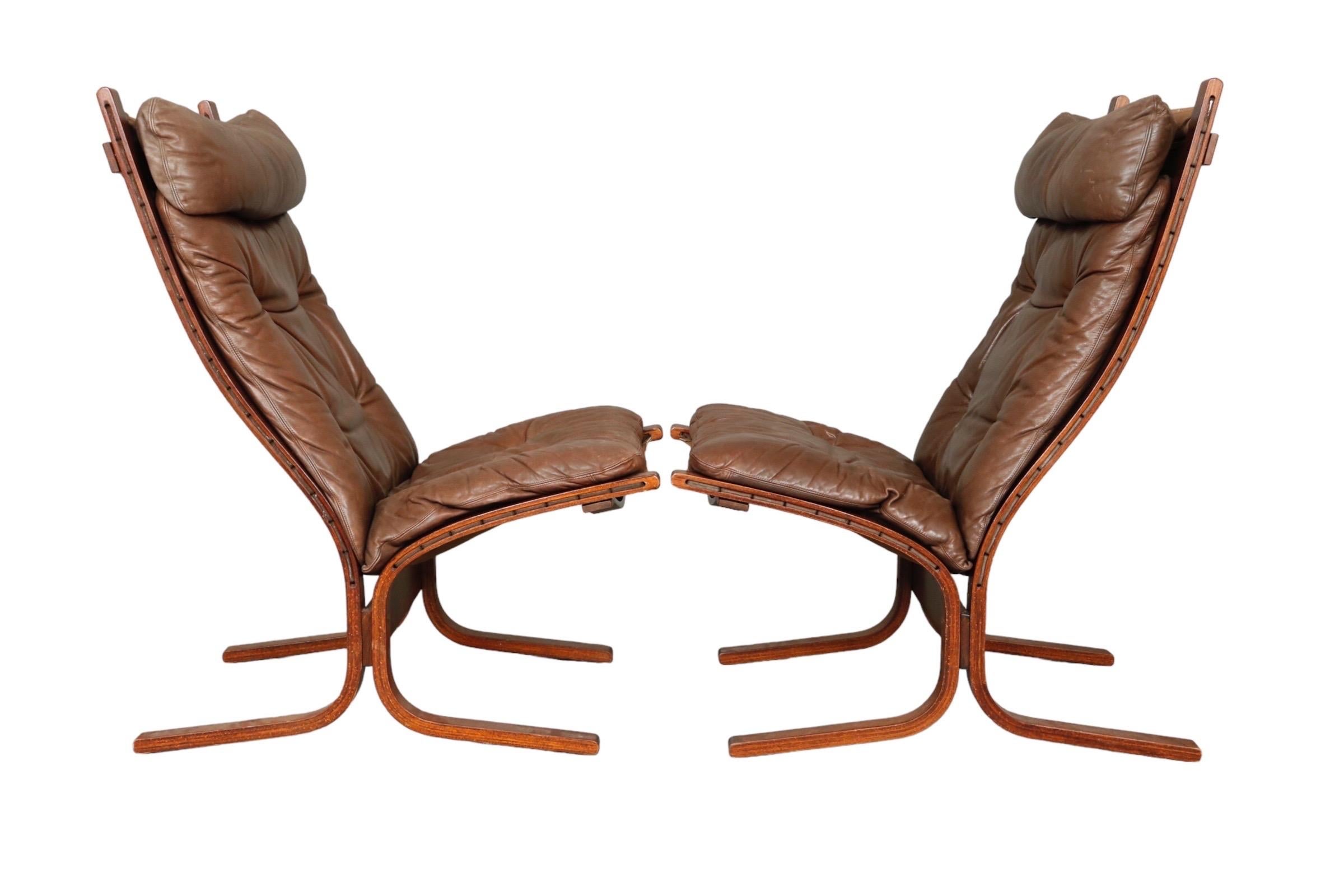 A pair of mid century modern ‘siesta’ lounge chairs by Westnofa Furniture of Norway. Original brown leather seats are button tufted with bentwood frames.