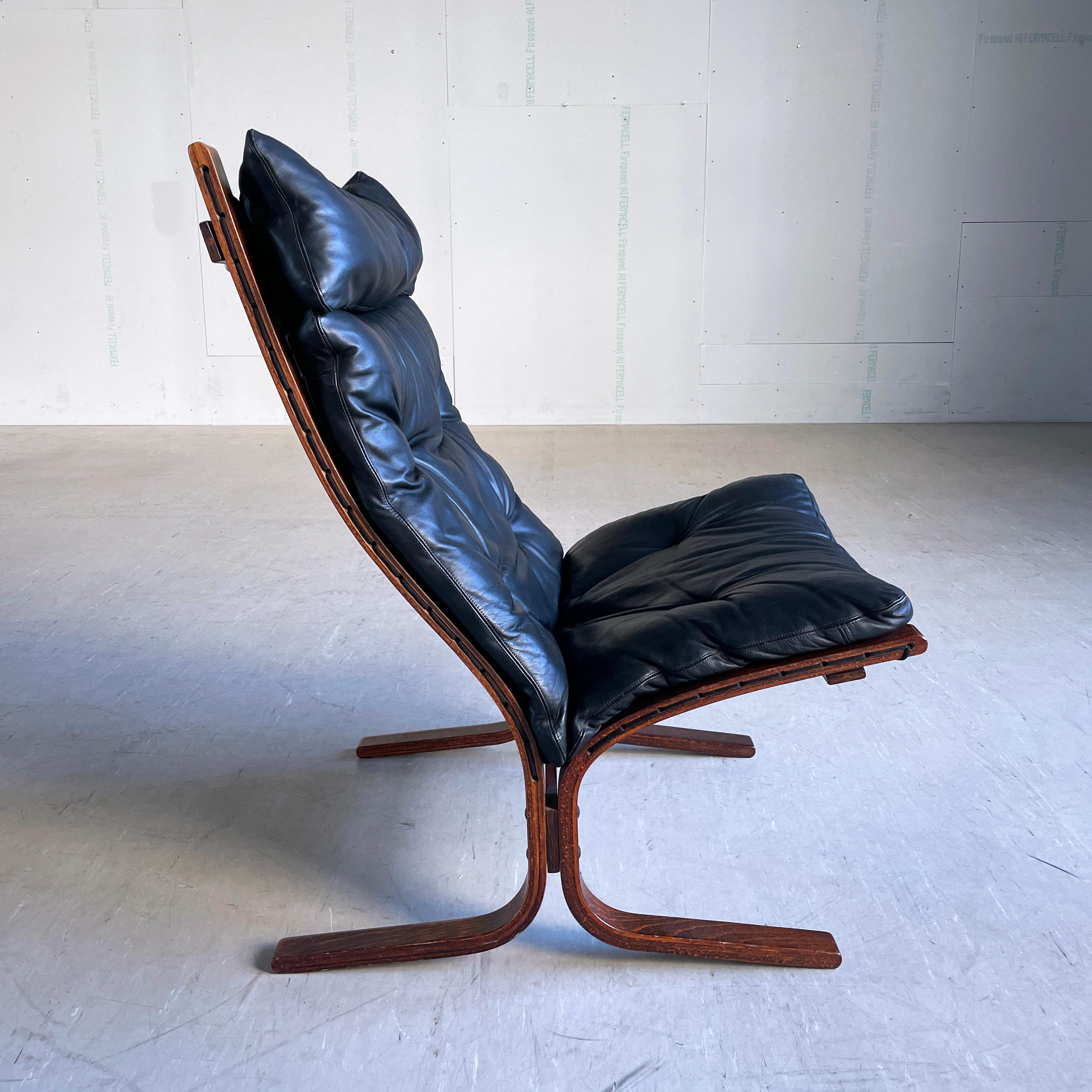 Ingmar Relling 'Siesta' high backed Lounge Chair. Bent plywood frame with sling black leather seat pads. 
Designed by Ingmar Relling, 1965. Produced by Westnova, Norway. Late 1970's / early 1980's production. 
Padding and frame in excellent