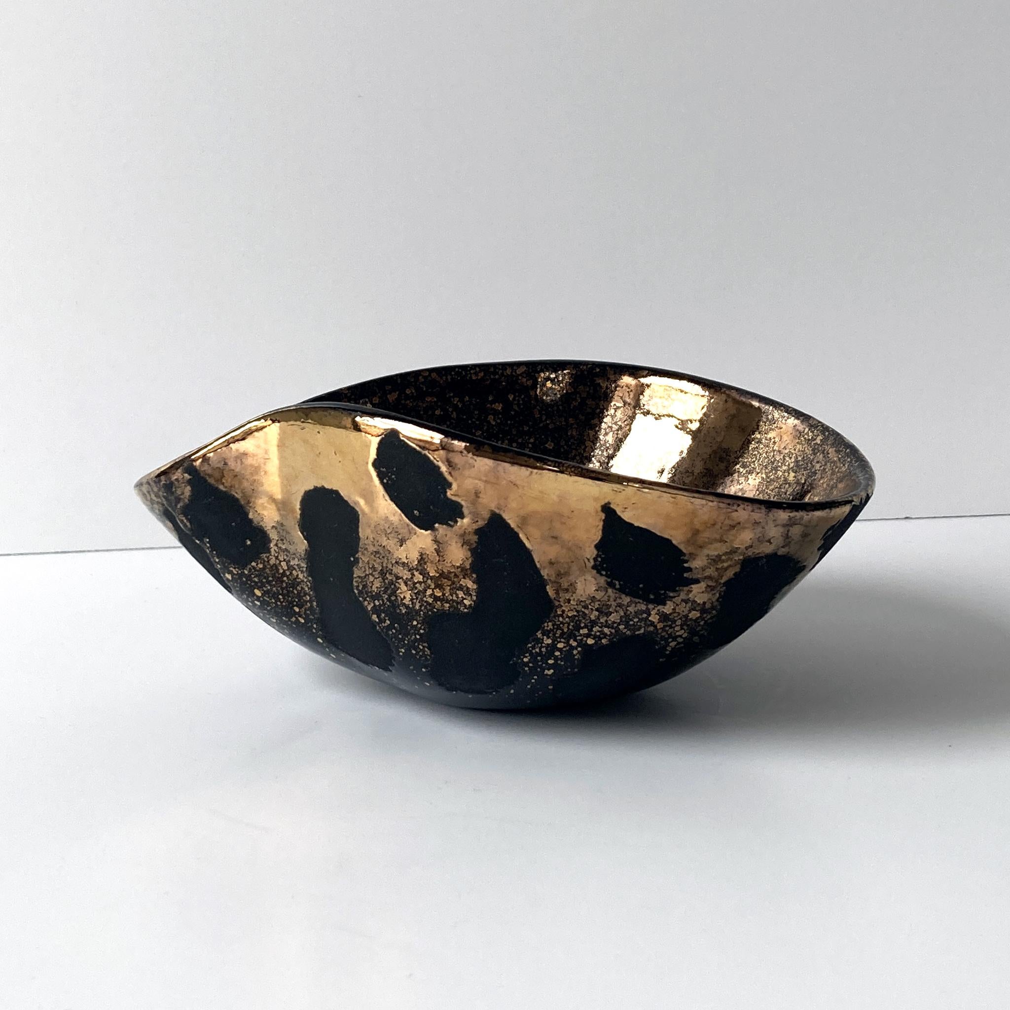 Striking gold and black centerpiece bowl by Westwood Ware California Pottery. The gold contrasts beautifully with the matte black pattern on the outside, this piece is stunning at different angles. Signed, Westwood Calif 711. In good vintage