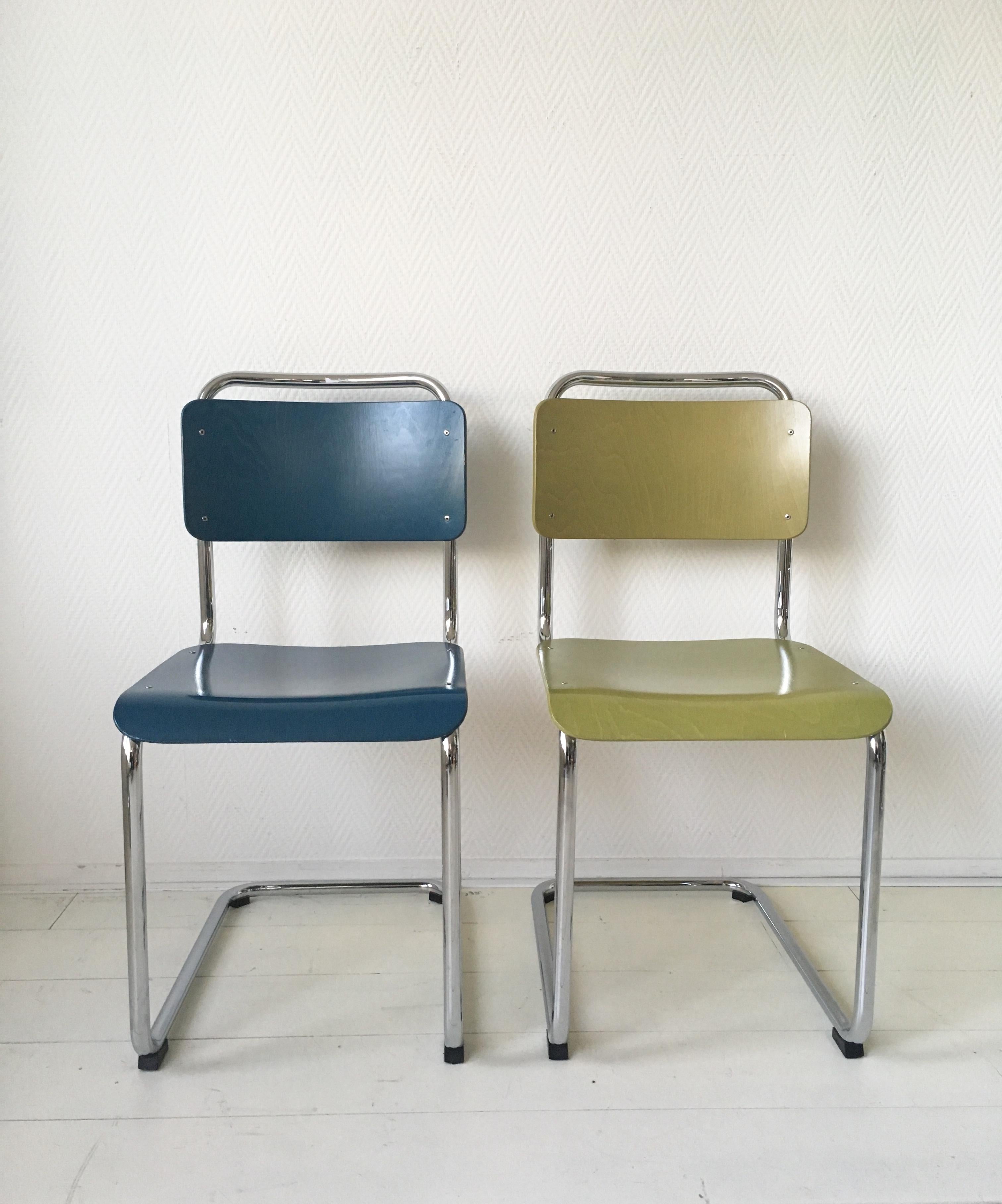 This wonderful set of four tubular dining room chairs, consist of two yellow pieces and two blue ones. They were designed by W.H. Gispen in the 1930s. Produced by license of Gispen International B.V. to B.V. Gebroeders van der Stroom. The pieces are