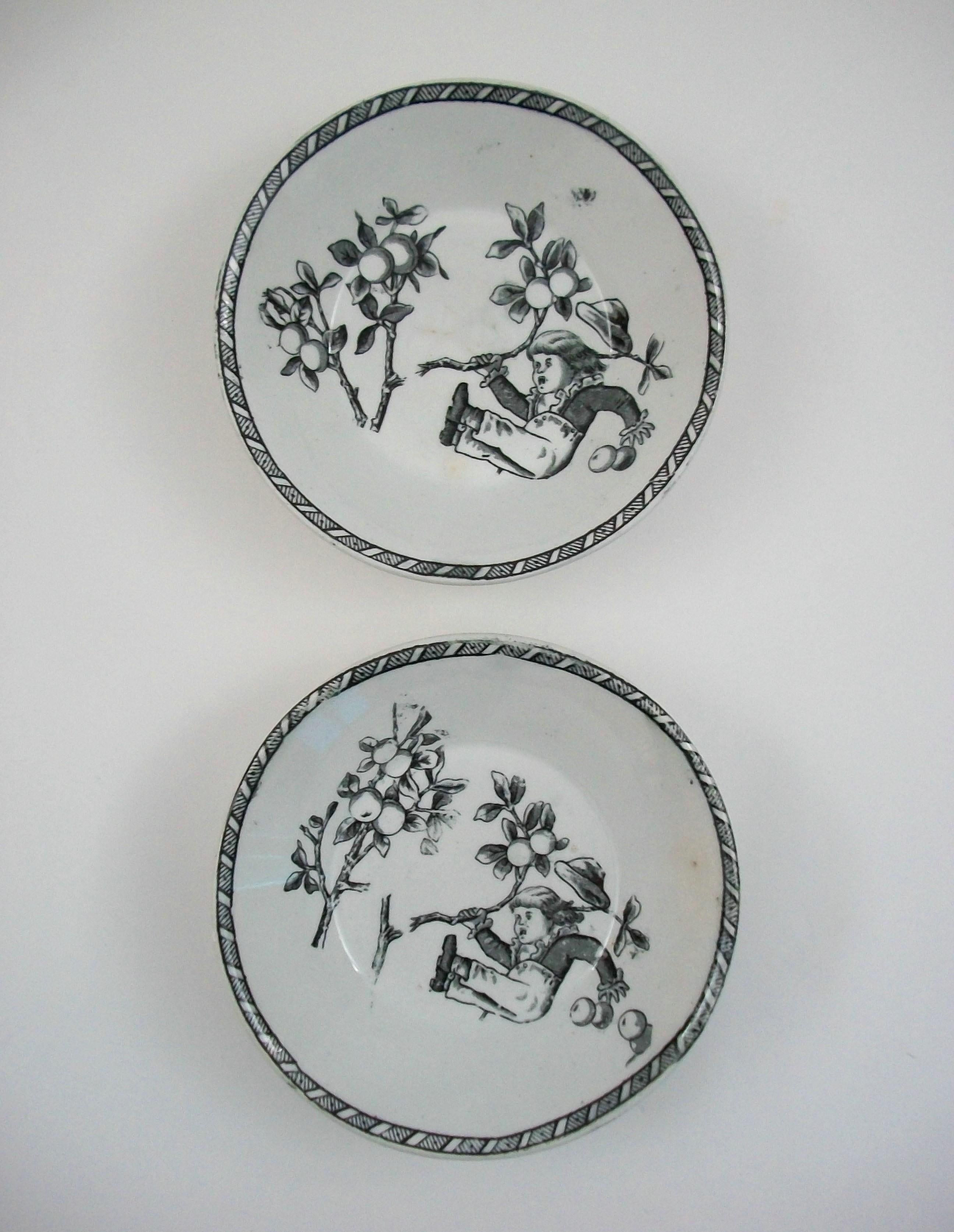 W. H. GRINDLEY & CO. - Daffodil - Set of two antique Victorian black transfer decorated fruit bowls - featuring whimsical prints to the center of each bowl with continuous printed borders - signed on the back of one (black printed back stamp and