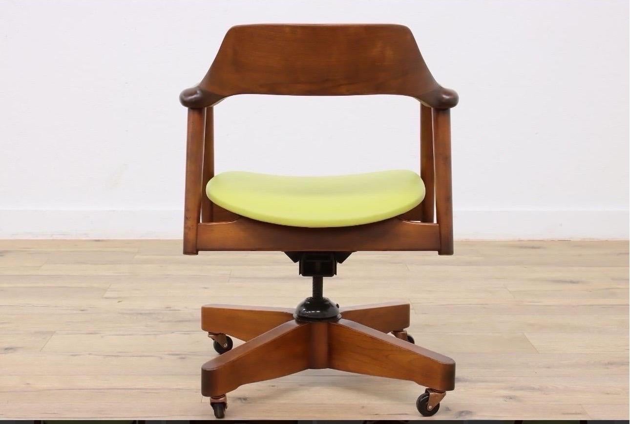 Una silla de escritorio vintage para oficina o biblioteca, con armazón de madera de nogal, asiento tapizado en piel y mecanismo giratorio de hierro para ajustar la inclinación y la altura.

Firmado 