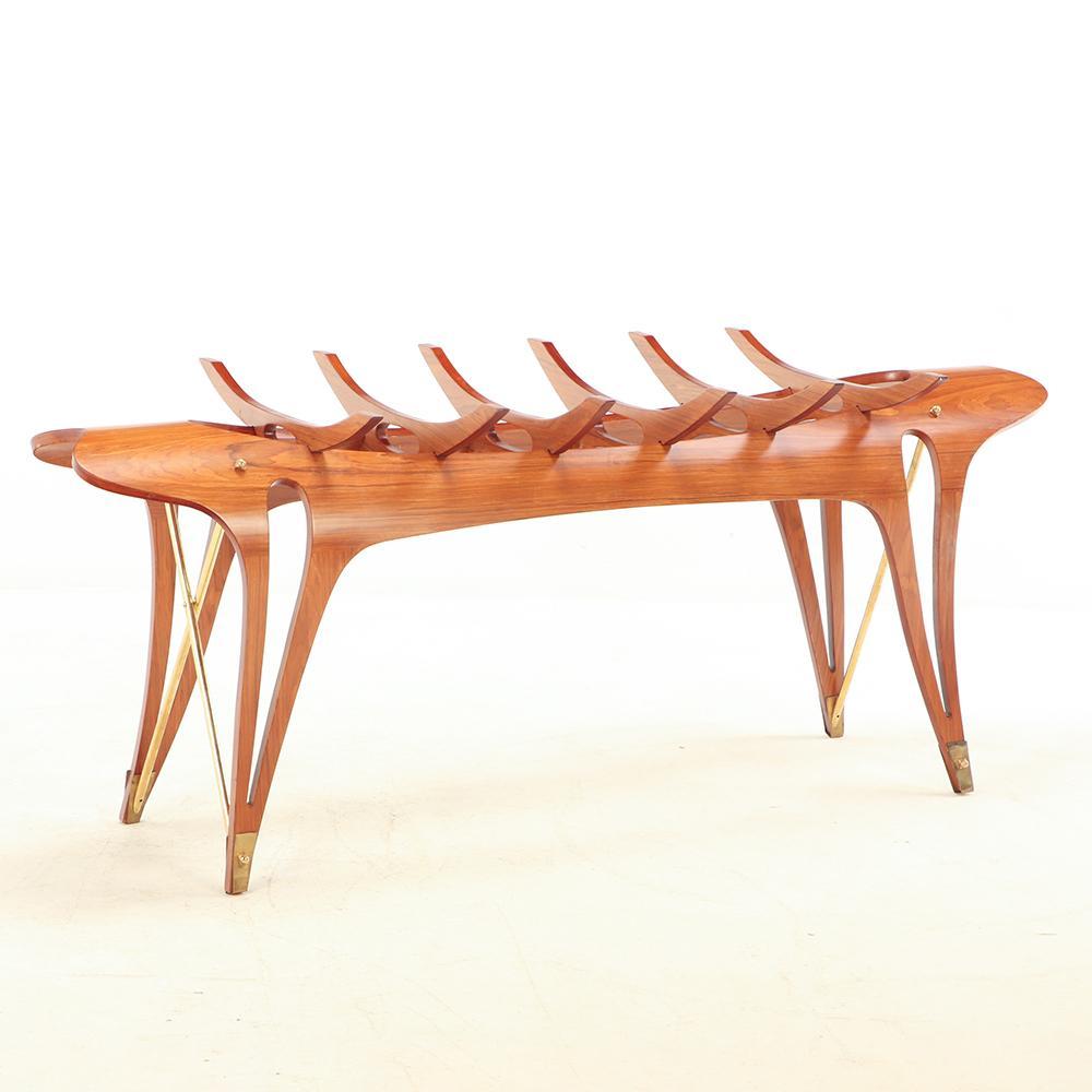 Realizzato in compensato impiallacciato, ottone e vetro, questo meraviglioso tavolo è un'aggiunta unica al tuo arredamento contemporaneo/marino/spaziale. Il tavolo presenta un piano rettangolare in vetro sostenuto da supporti in stile organico e