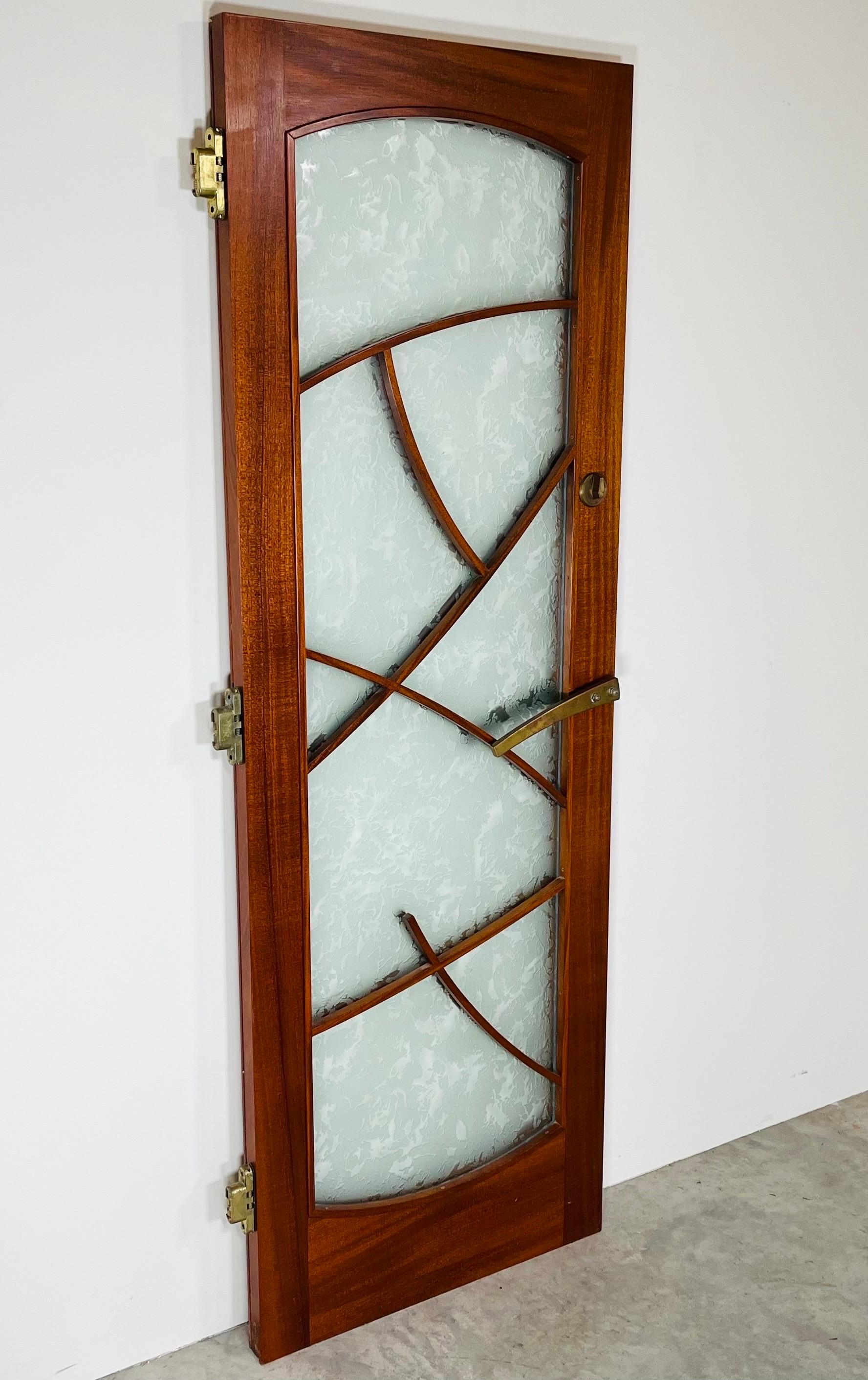 A beautiful custom outer door having West African albizia solid wood frame with double panel frost effect glass panels, solid bronze lever pull on both sides and SOSS concealed invisible hinges in the manner of Wharton Esherick. 
 Extremely well