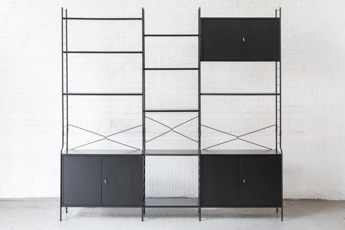 Freestanding shelving system by WHB, designed and produced in Germany in the 1960s. Metal and black painted wood design, easy to install and adjust. The system features three cabinets with hinging doors, each with a single shelf on the inside. The 9