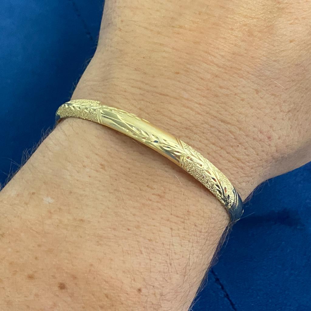 This slim bangle bracelet has a beautiful mix of finishes with wheat designs engraved across the domed surface. The bangle is 0.24-inch wide and 2 3/8-inch by 2 1/8-inch wide on the inside and will fit up to a 7-inch wrist. This was originally