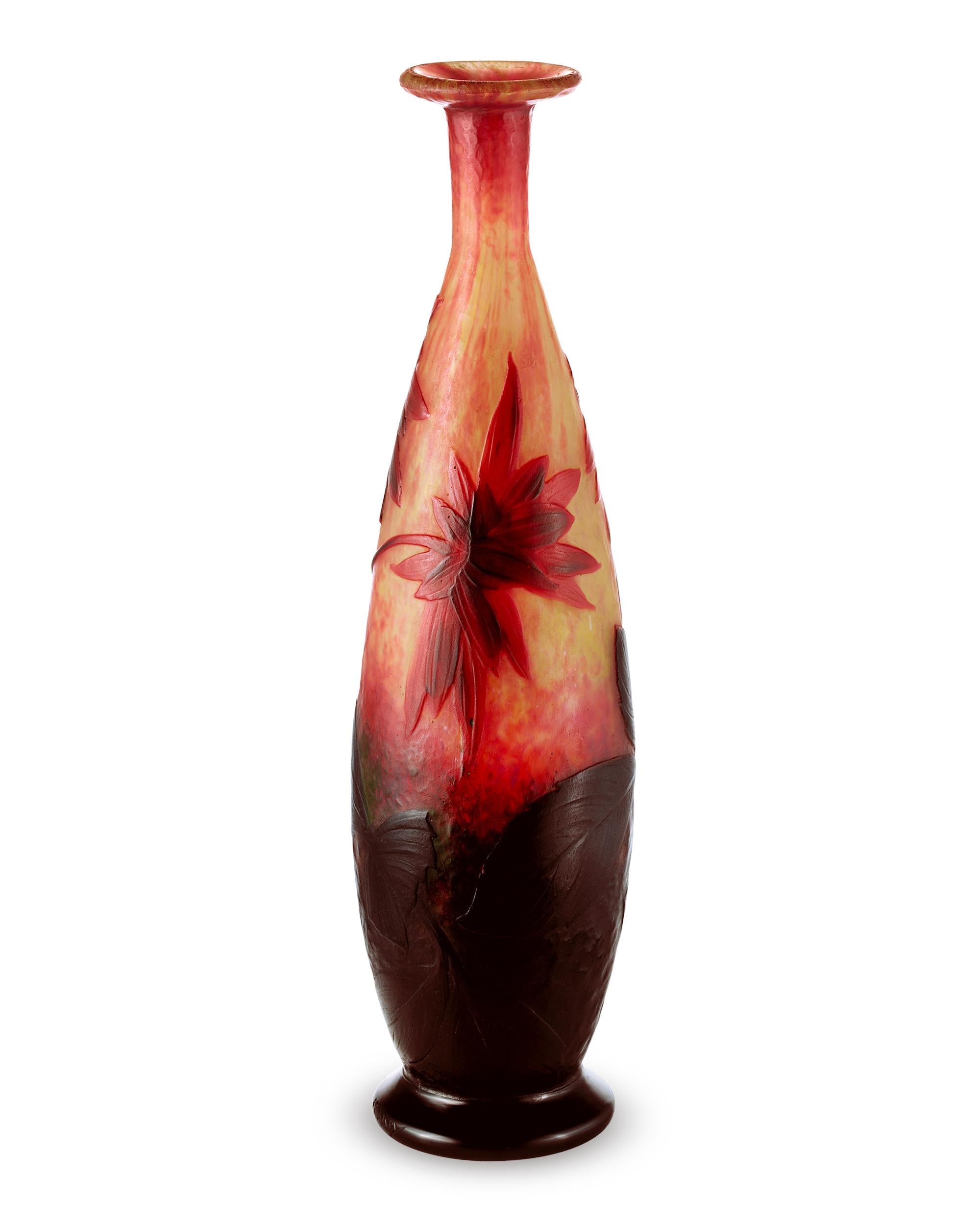 Ce rare vase de Daum Nancy témoigne de la superbe qualité et des détails qui font la réputation du verre camée de la firme. Des fleurs d'un rouge éclatant ont été gravées à l'acide sur un fond jaune-orange vibrant. L'imagerie a ensuite été