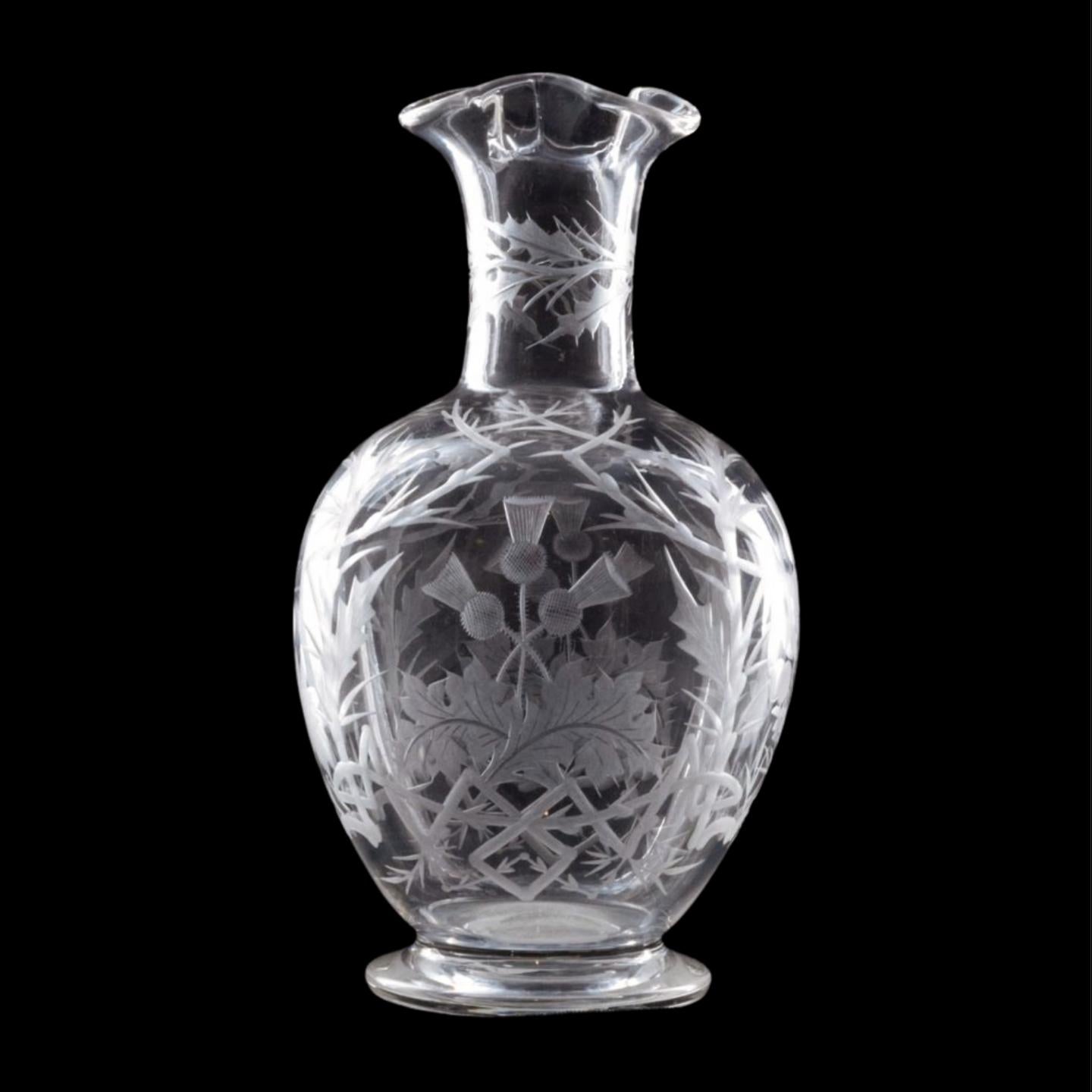 A carafe of pleasing shape & proportions, with elaborate wheel-cut decoration of thistles and thorns. Possibly intended for whisky - or at least the water to be added to it; but it could also be of Scottish Nationalist symbolism.

Stourbridge glass