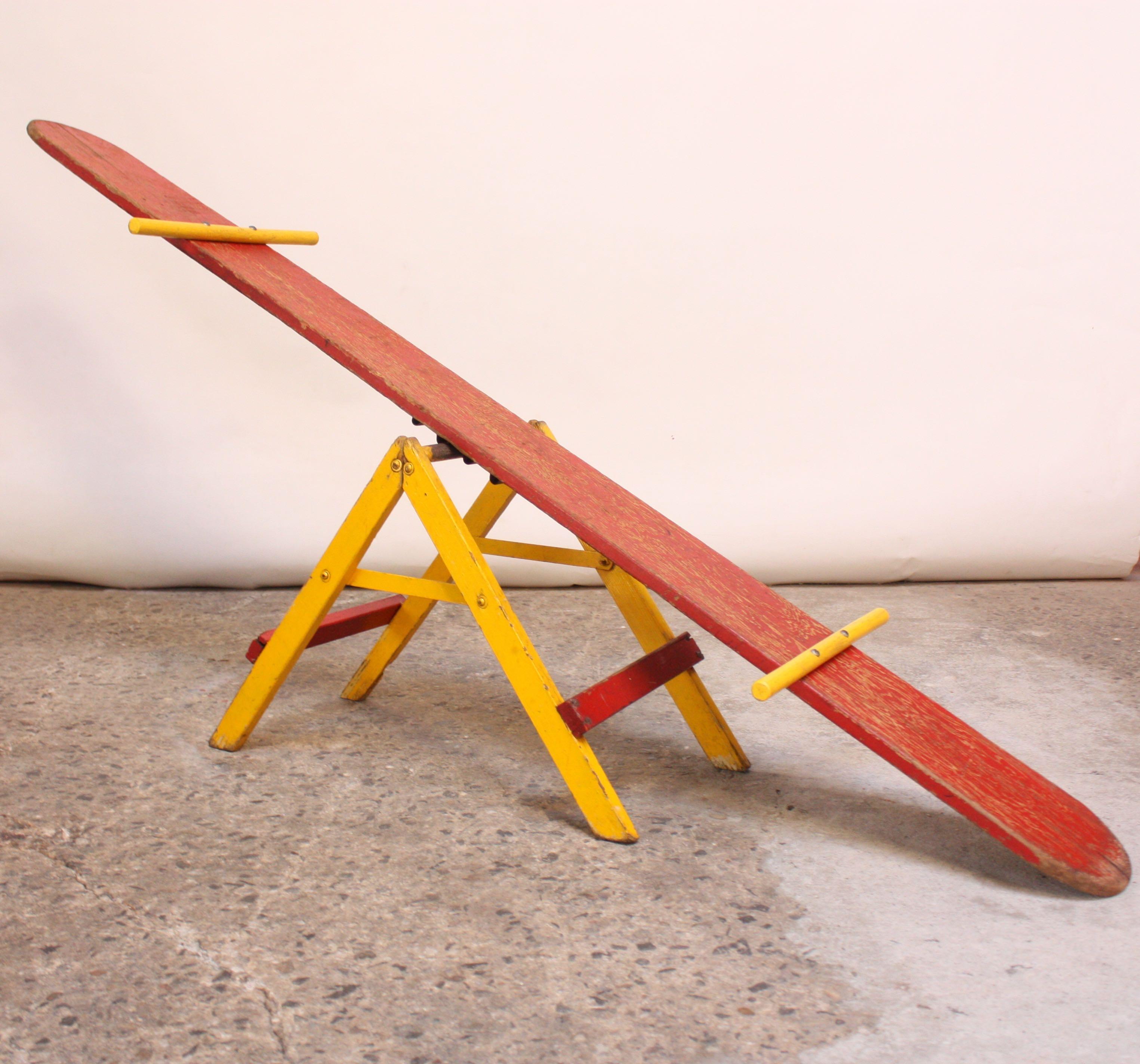 Children's seesaw (circa 1950, USA) in painted oak with lovely, natural patina. Although, impractical for intended use, given the wear and age, this remains a charming, decorative item. Additionally, can be used as a display for lightweight items,