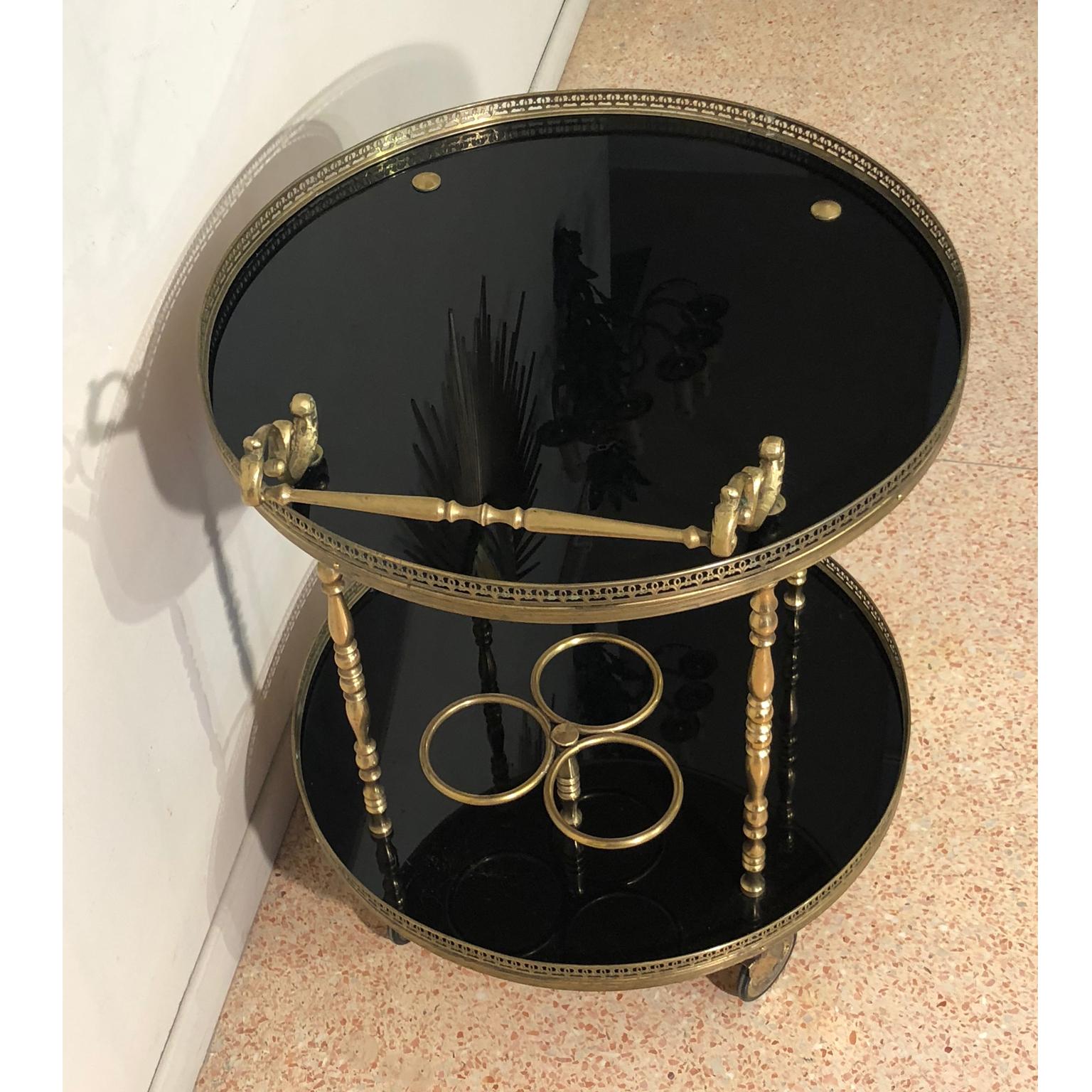 Brass and shiny black lacquer rounded bottle holder tray, France 1940s. Four wheels make it easy to be moved around. This tray has two shelves lined with brass crown. It comes from France from 1940s. We have restored the brass parts and re lacquered
