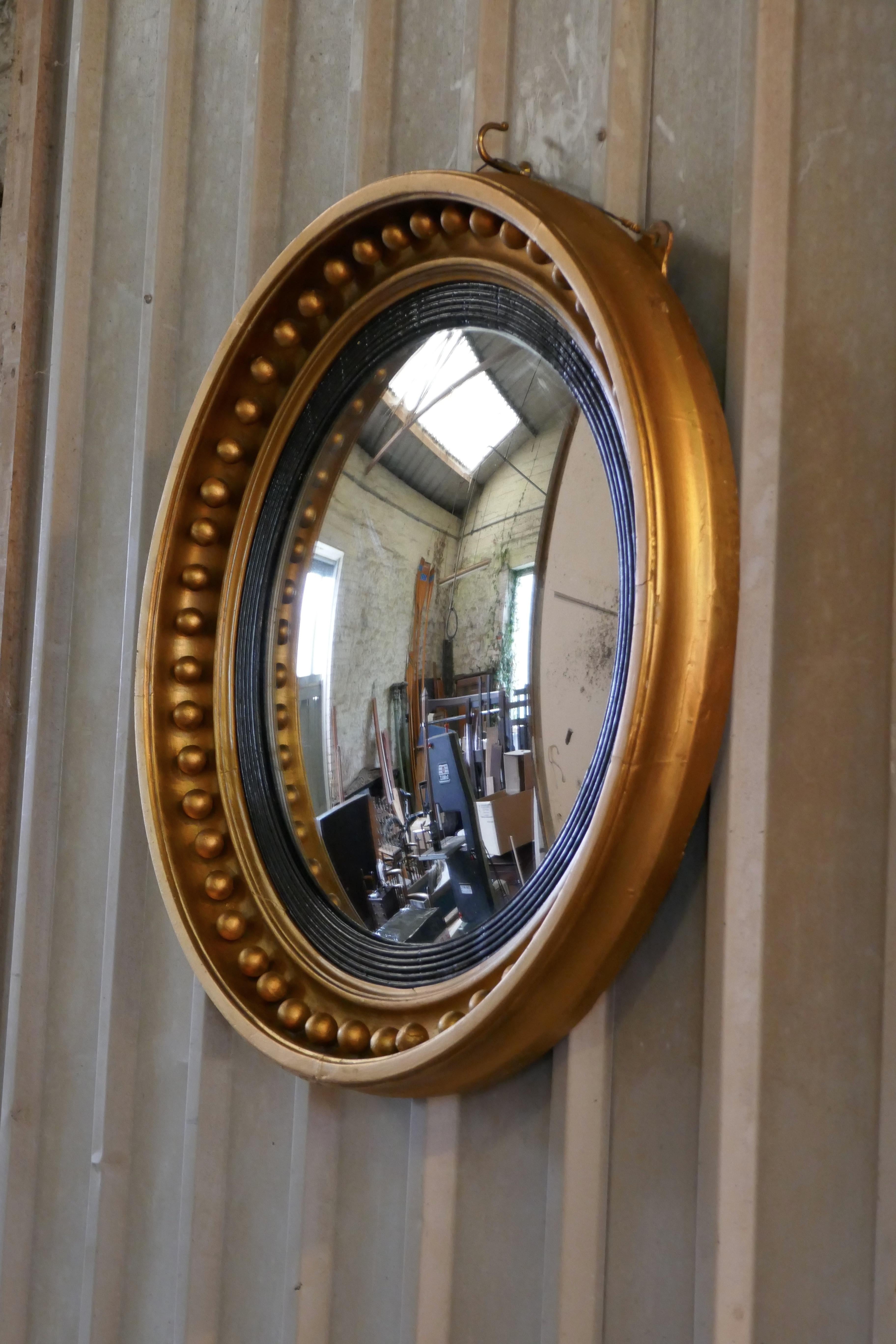 A large Regency convex gilt wall mirror 


This stunning mirror has a deep gilt frame decorated with large spheres, the convex glass is held with a reeded ebony mount

The large 4.5” round frame is in sound condition as is the original convex