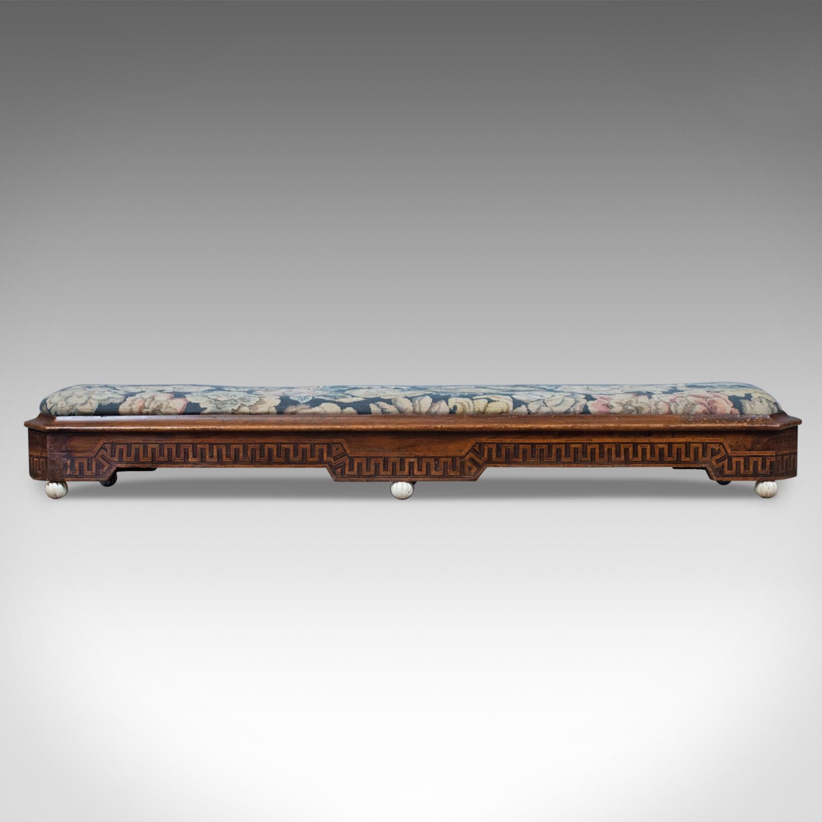 This is an antique carriage stool, a long, Victorian footrest in walnut with needlepoint tapestry upholstery and dating to the mid 19th century, circa 1860.

Solid walnut, displays well with a wax polished finish
In biscuit hues, grain interest