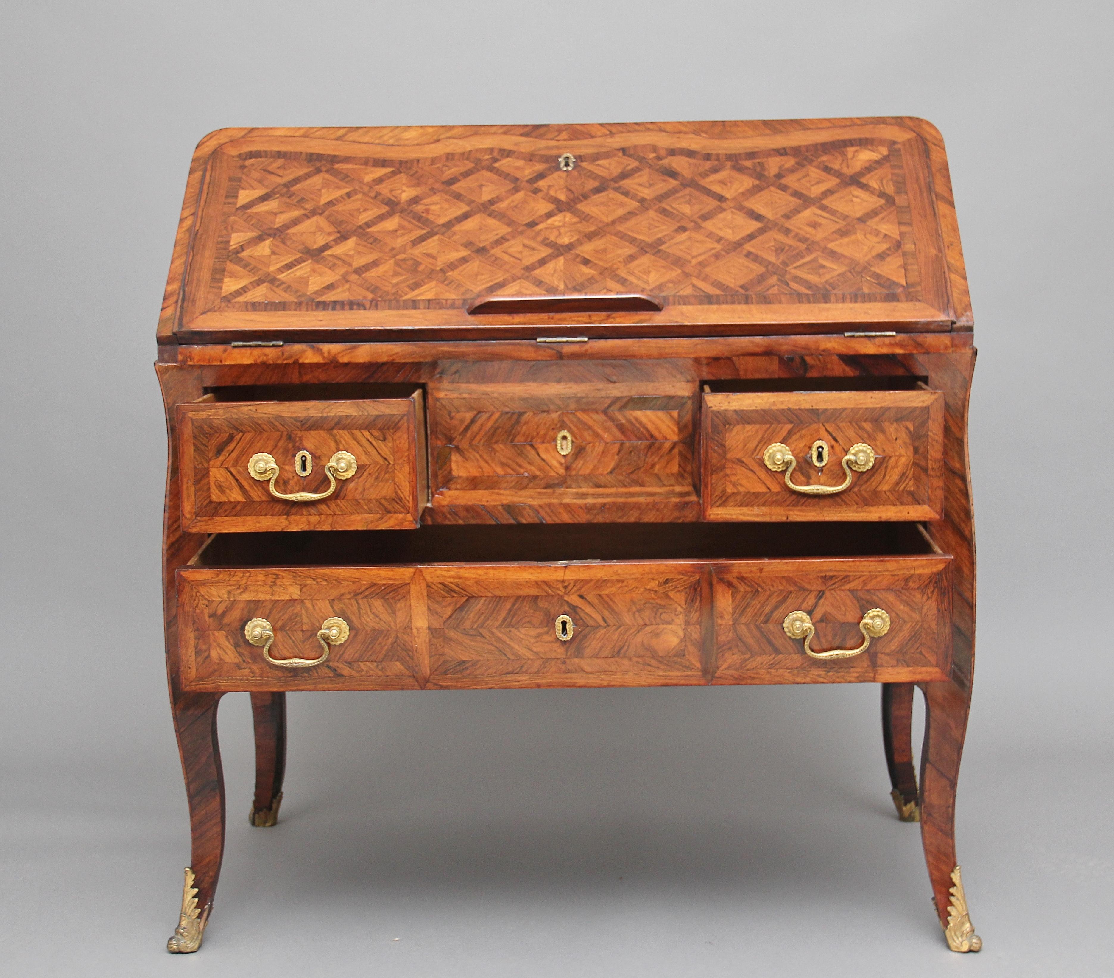 A superb quality 18th century French Kingwood desk, the shaped fall having parquetry design, opening to reveal a green leather writing surface decorated with blind and gold tooling, having a lovely fitted interior with various drawers and