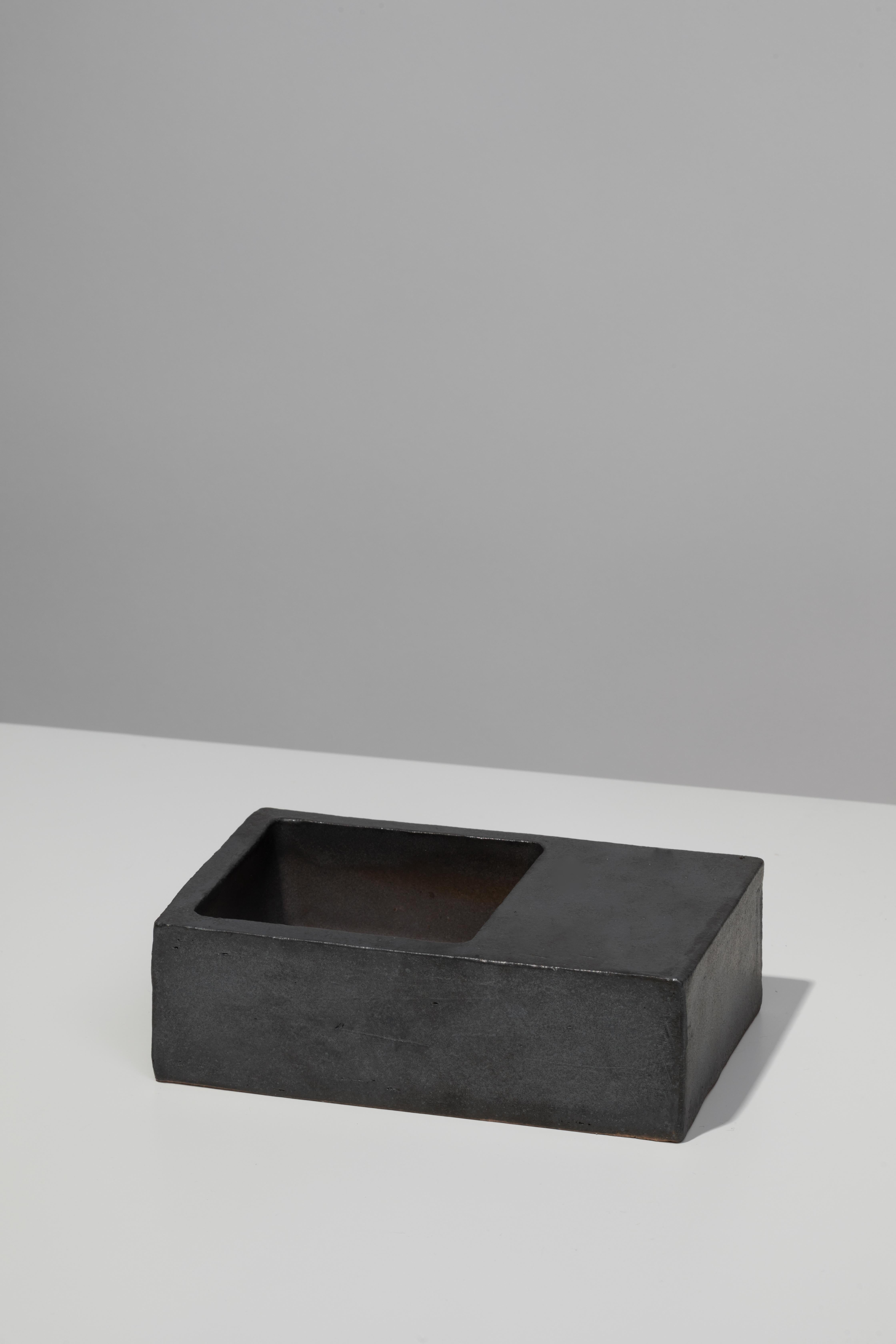 Slab-built ceramic vessel with black coppered glaze. Marked with an engraved bronze label to underside: Jonathan Nesci w/ Robert Pulley 18/01. 

Designed by Jonathan Nesci and made in Columbus, Indiana by local ceramist Robert Pulley for inaugural