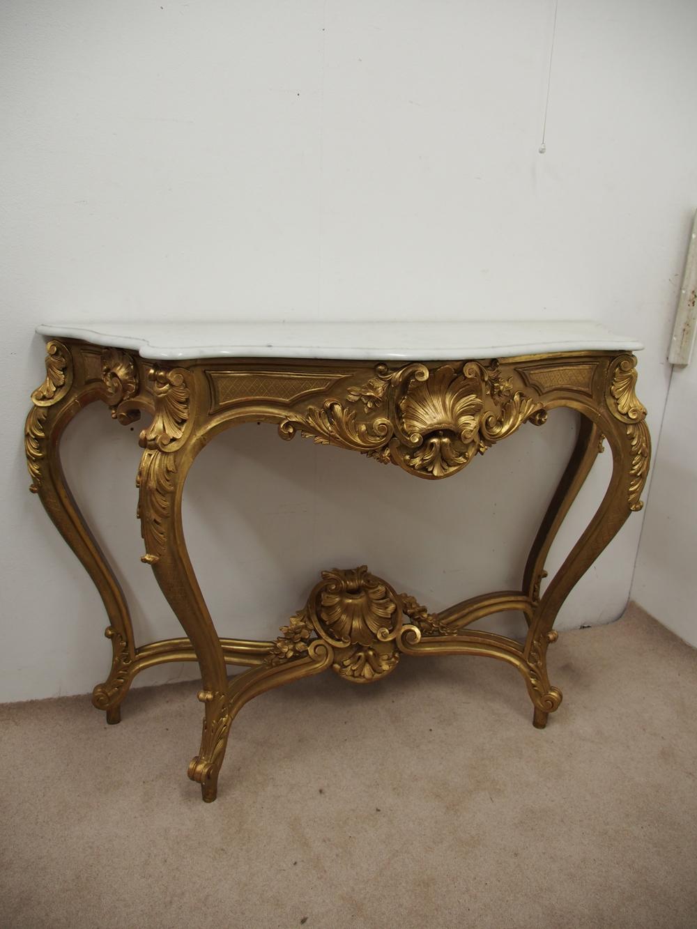 Victorian gilded, and carved wood console table with marble top, circa 1870. With half rounded edge to the top, and made in a high Rococo style, with carved shells and foliate carving to the front. There are 2 cabriole legs to the front with carved