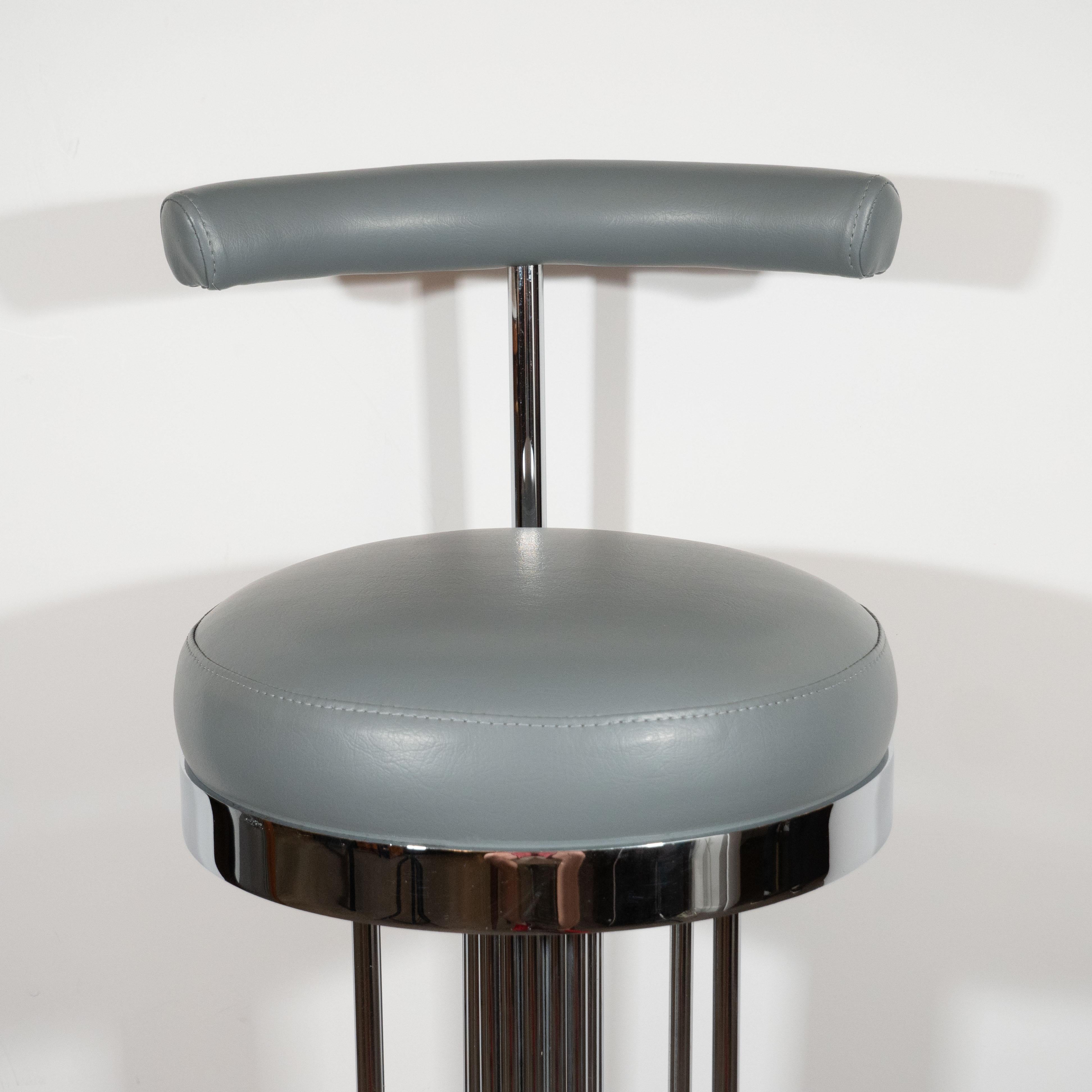 This sculptural and elegant set of three mid-century modern bar stools were realized in the United States, circa 1970. They ribbed chrome bodies consisting of an abundance of adjoined bars that collectively create a cylindrical form. These bars