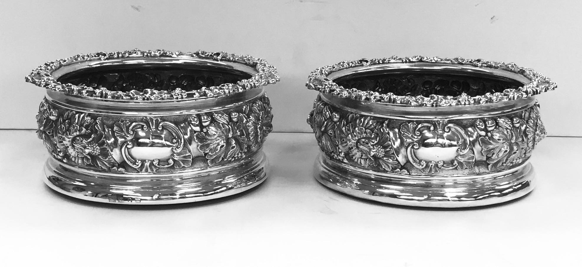 A pair of antique English sterling silver wine coasters, each large enough to hold a magnum.
They were made during the reign of George IV by the firm of S.C. Younge, and bear the hallmarks for the city of Sheffield, 1828/29 and
They have traces of