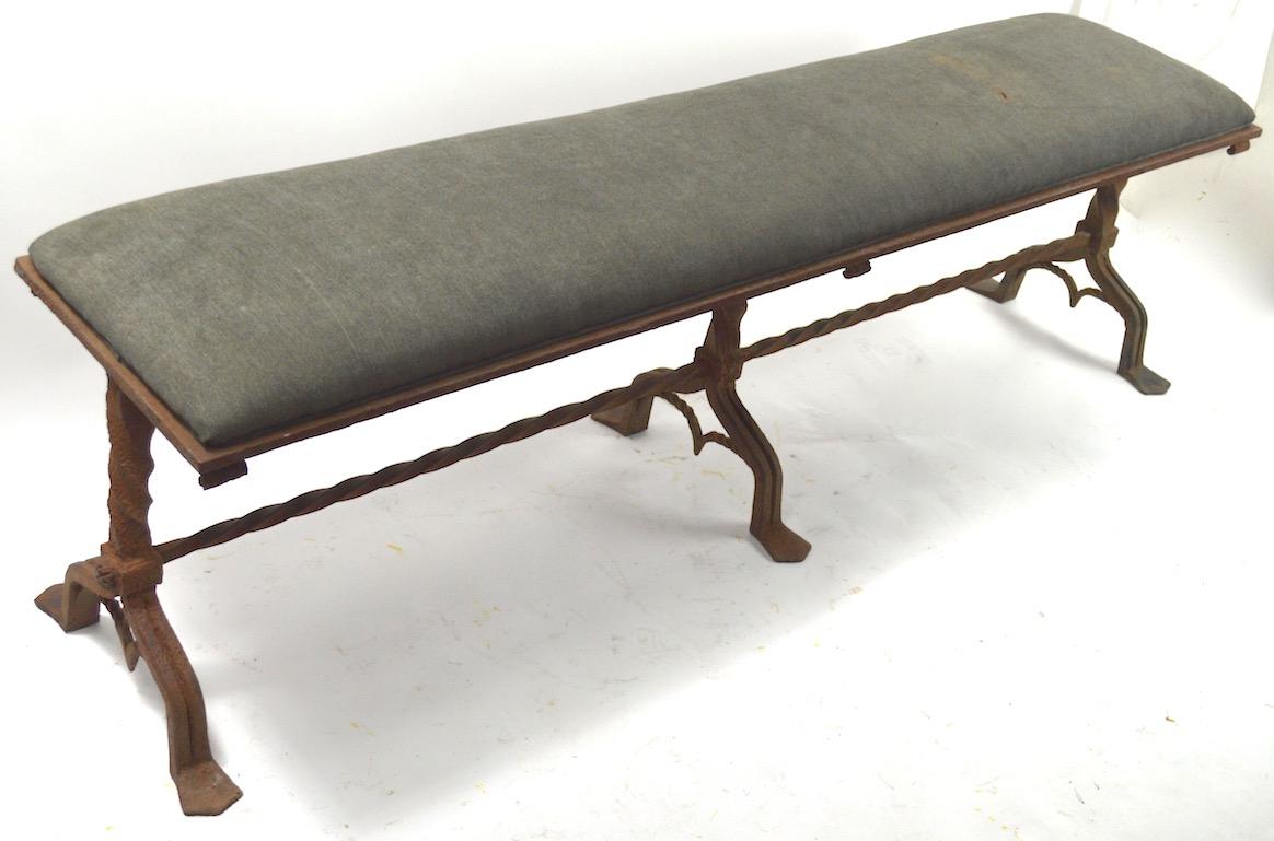 Exceptional Gothic Revival bench of heavy wrought iron with upholstered top. Impressive craftsmanship, scale and presence. We believe the bench is American, however this caliber and style was more commonly Continental in origin. 
 The metal surface