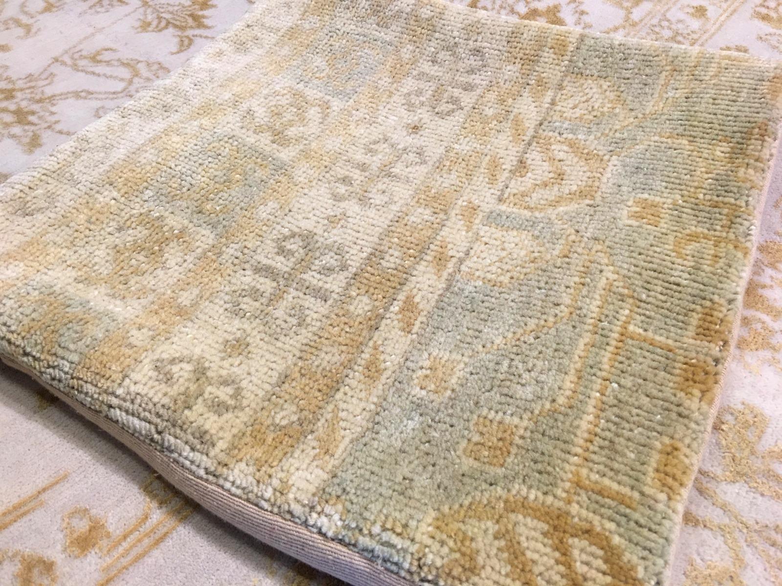 Magnifique housse de coussin en tapis de style Khotan noué à la main, en laine. Belle couleur délavée, support en textile de coton, avec fermeture éclair. Livré sans remplissage.
