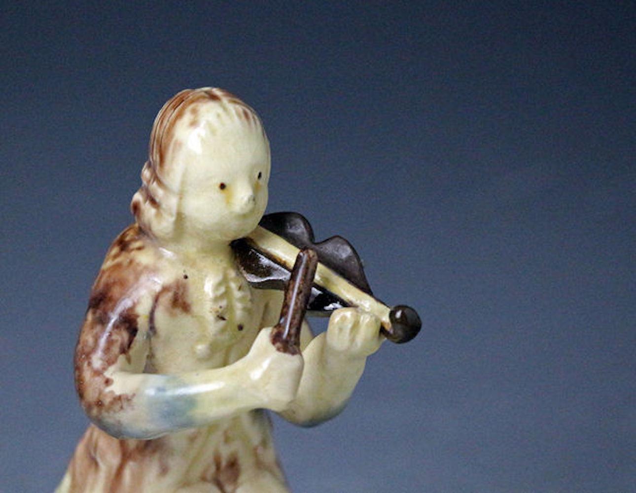 Early English pottery Staffordshire figure of a seated violinist. The figure is made with two colored clays in the Astbury- Whieldon style. A rare and charming piece from the early days of the Potteries.

Dimensions: 2.00 inch wide 5.00 inch high