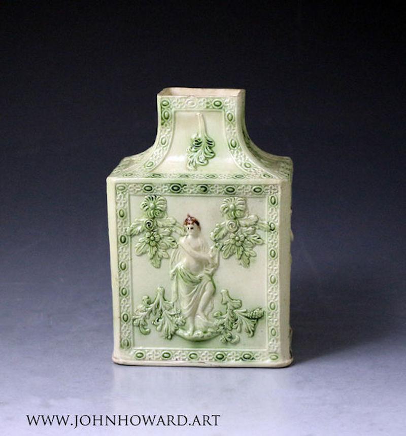 Dated: 1765 Staffordshire England

Staffordshire pottery green glazed pagoda top tea caddy with four panels, showing in relief a female figure dressed in the classical form playing the lyre. The glaze is excellent, and the modeling is crisp and