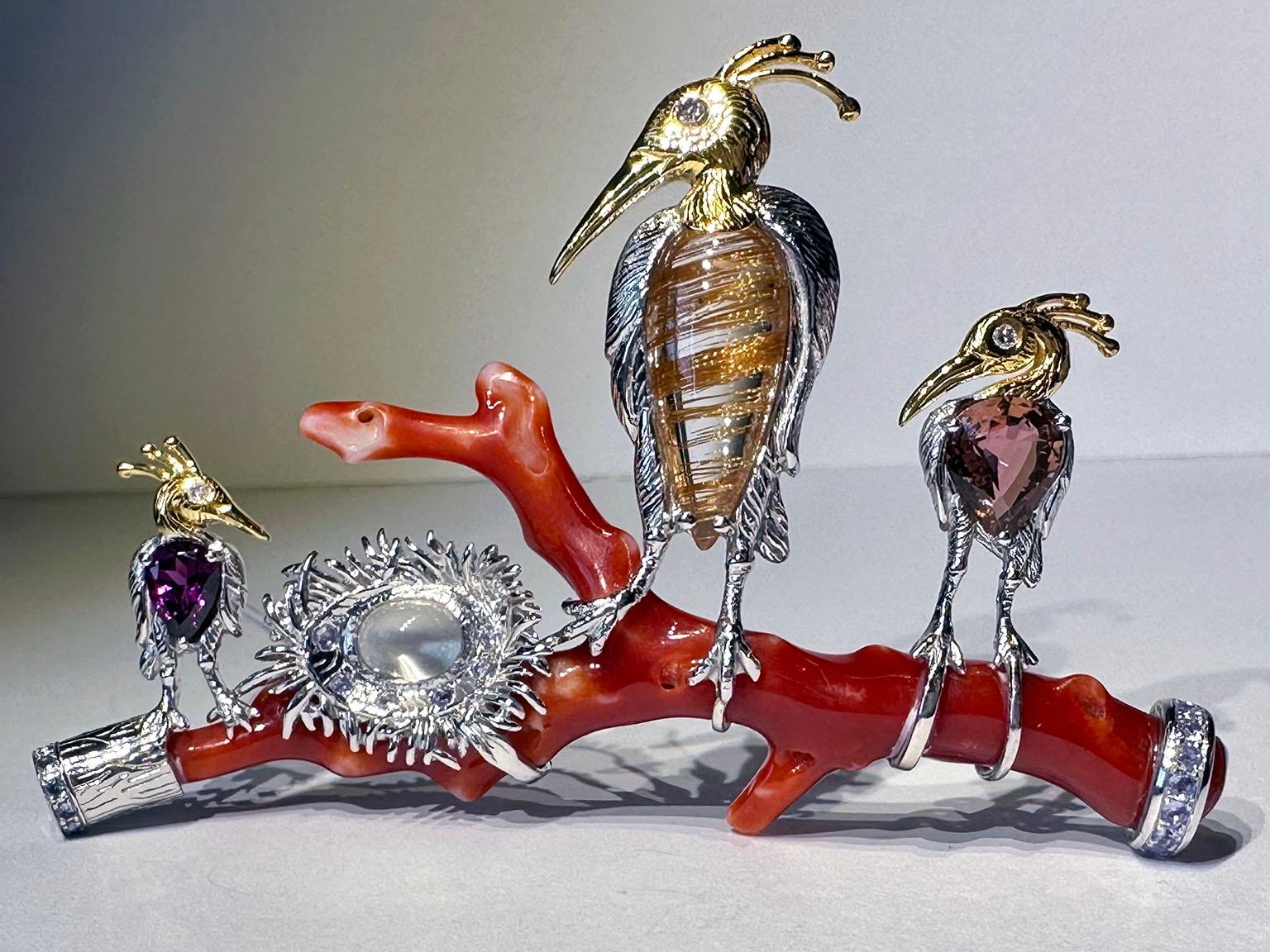 This is a one-of-a-kind masterpiece by Kary Adam. A Whimsical Bird Roost Brooch featuring a Red Coral Branch, perched on by 3 birds, set with a pear cut Rhodolite Garnet, a pear cabochon Rutile Quartz and a pear cut Pink Tourmaline. Each bird has a