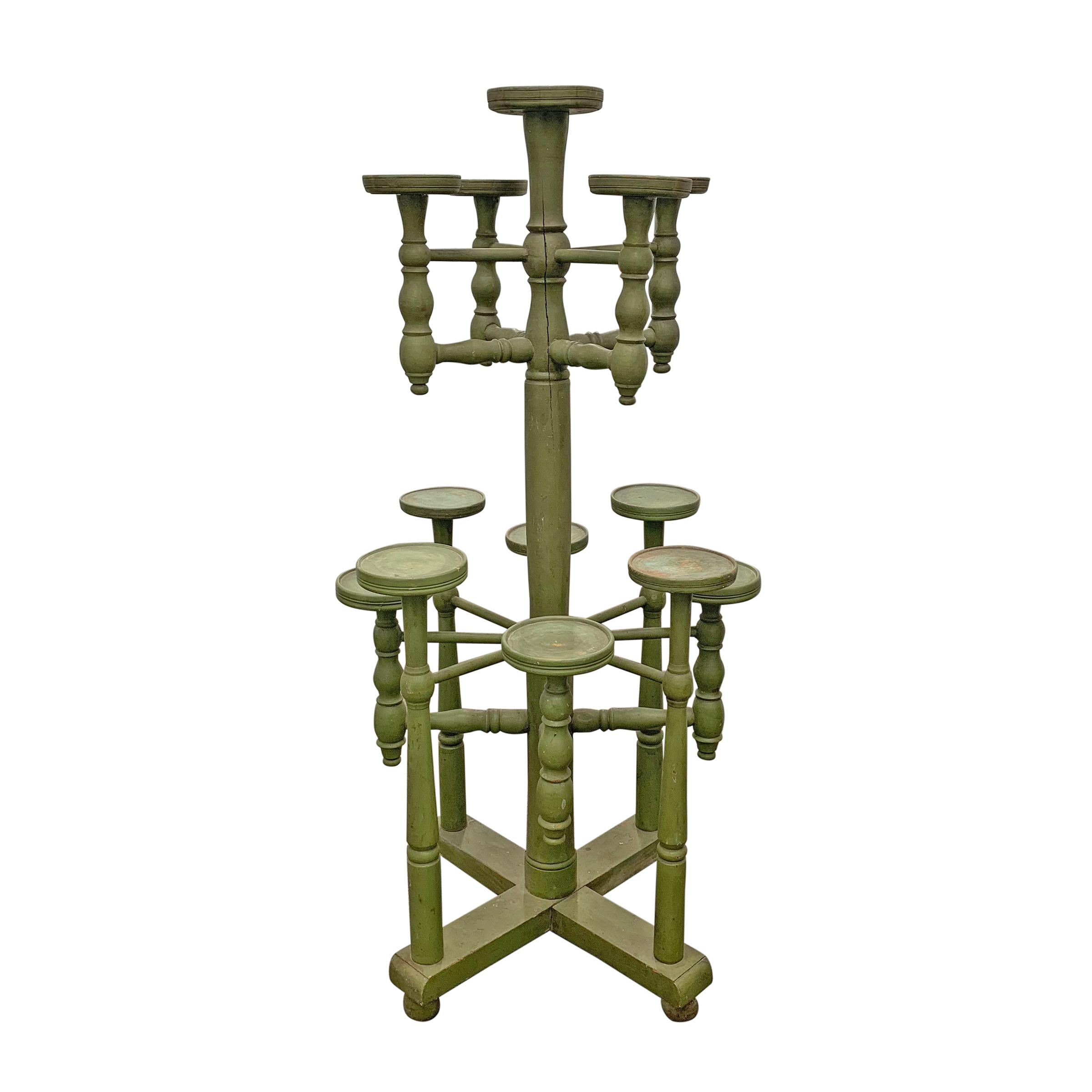 A whimsical 19th century English three-tier plant stand with thirteen arms and retaining its original British racing green paint. Such a fun addition to your sunroom, orangerie, or conservatory.