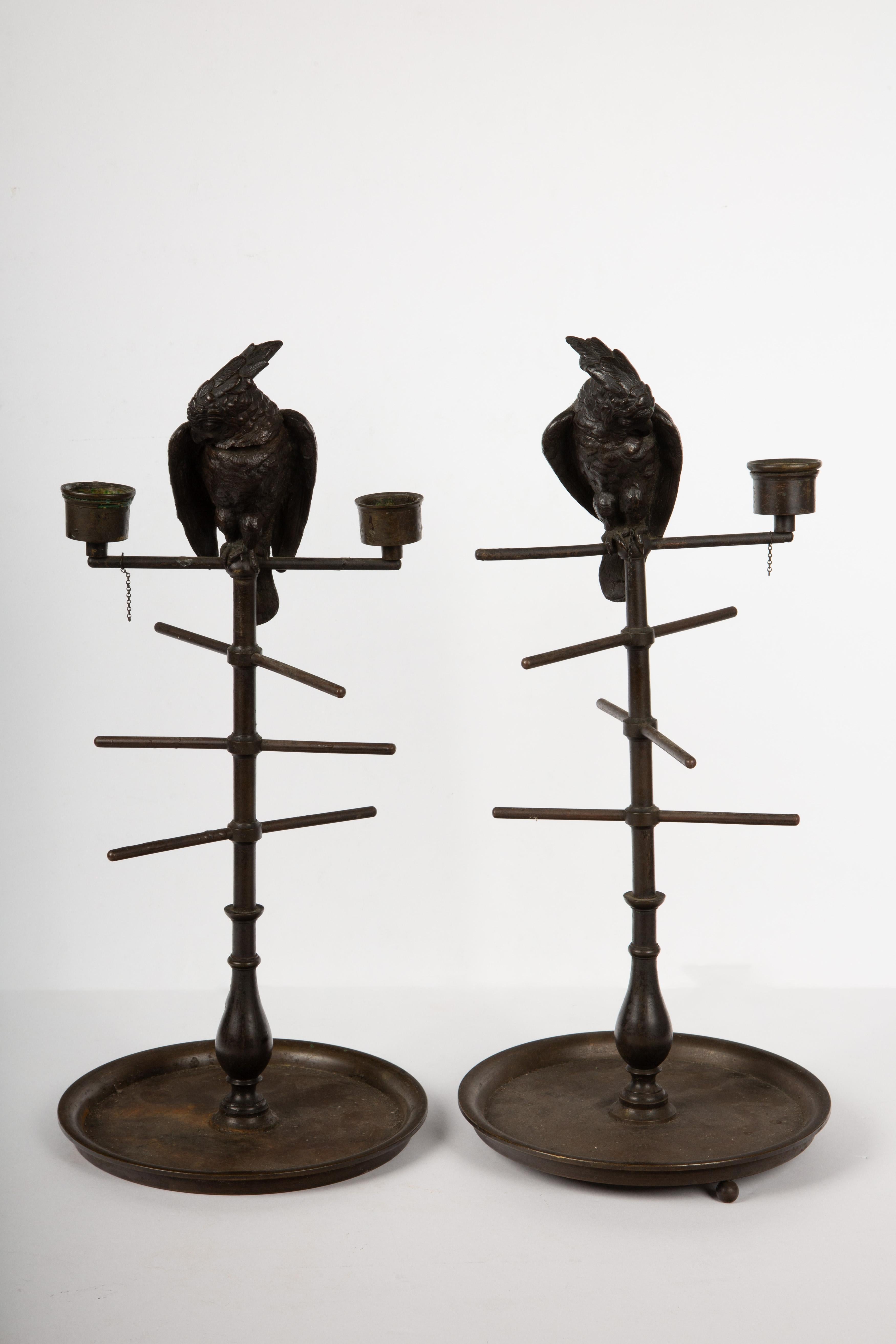 These exquisite 19th-century bronze parakeet on perch candlestick inkwells showcase the fine craftsmanship of the era. Each inkwell features a beautifully designed parakeet with a hinged head that opens to reveal a well for ink. The intricate