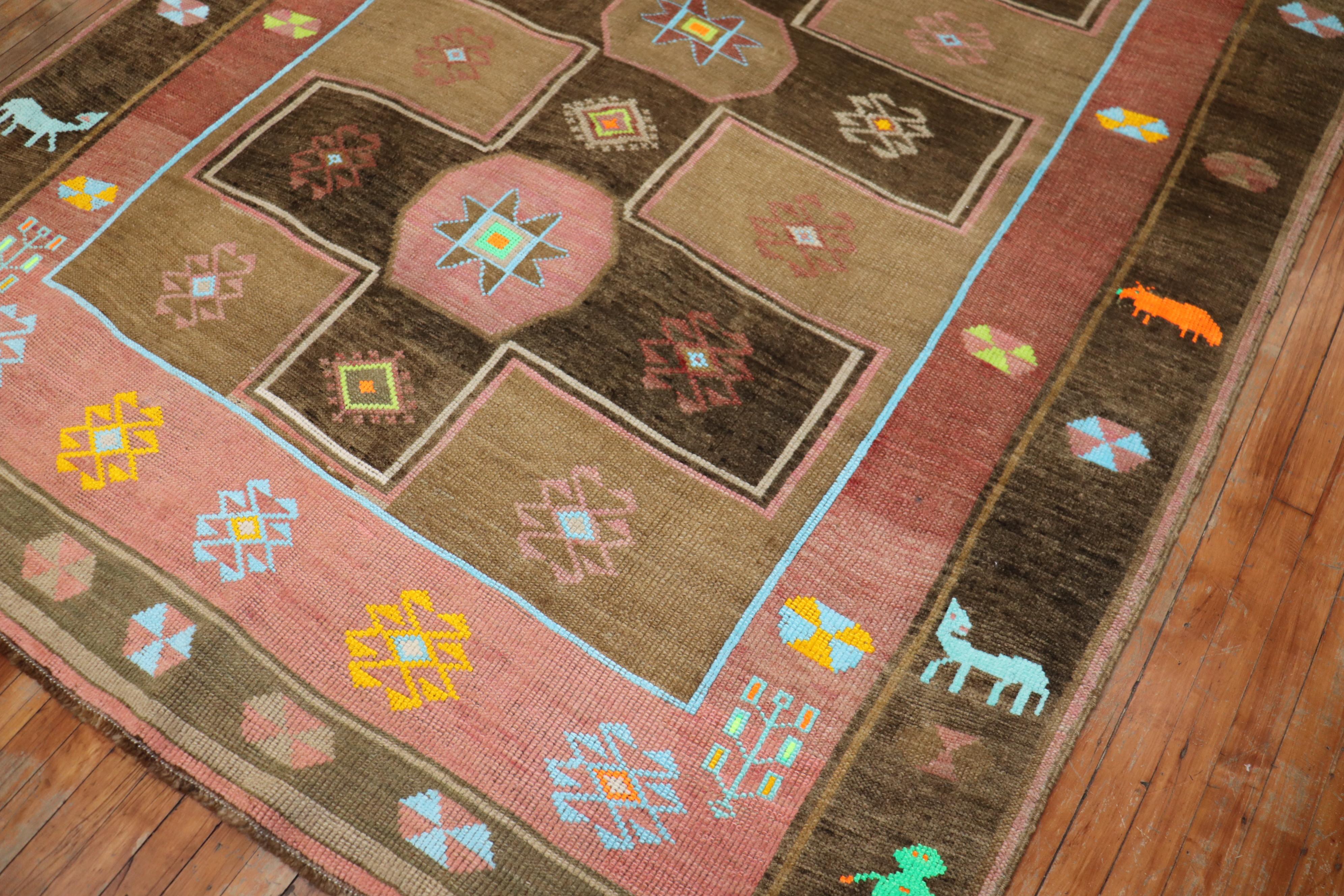 A whimsical mid-century colorful Turkish Kars rug. Field is brown, the border has 2 human figures and animals. 

Measures: 6'8