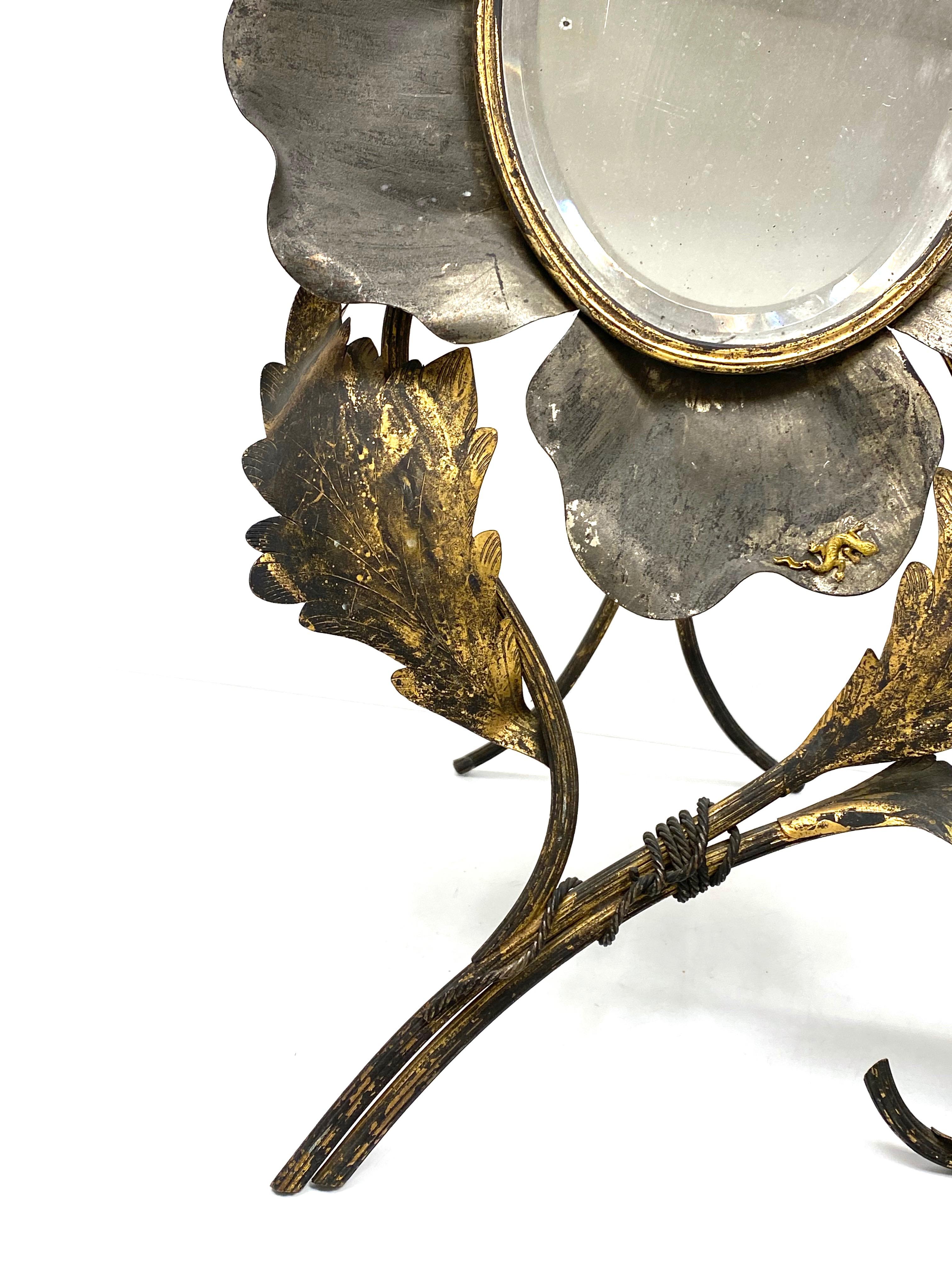 A gorgeous distressed glass vanity mirror made of Metal. With signs of wear as expected with age and use. Can be used as standing or wall mirror. Lost some of the gilt, but this is old-age. Have you seen the small petite little lizard at one of the