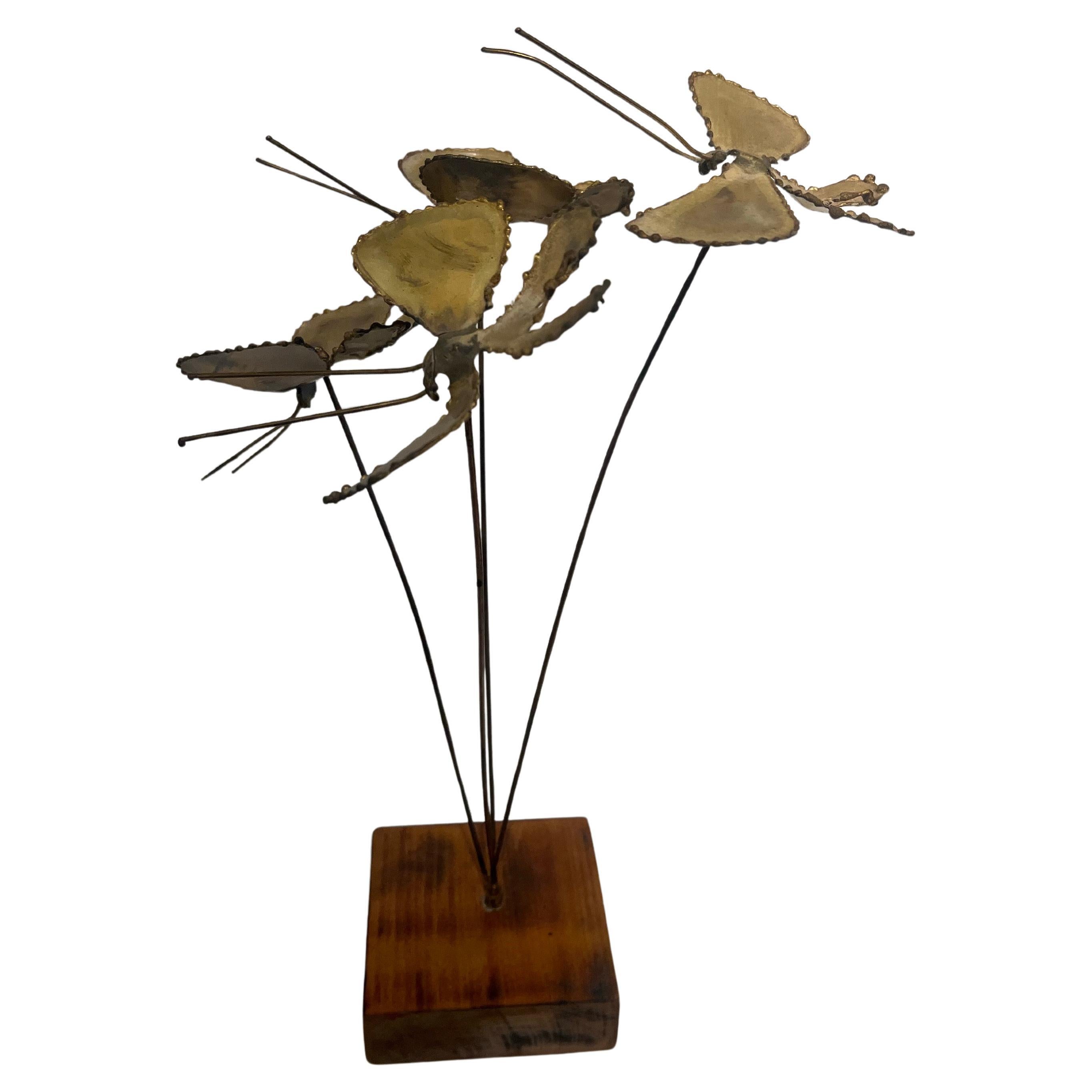 Semplice e bella scultura in ottone saldato di una farfalla che vola seduta su una base in legno massiccio non firmata degli anni '70 circa, un pezzo ben fatto.