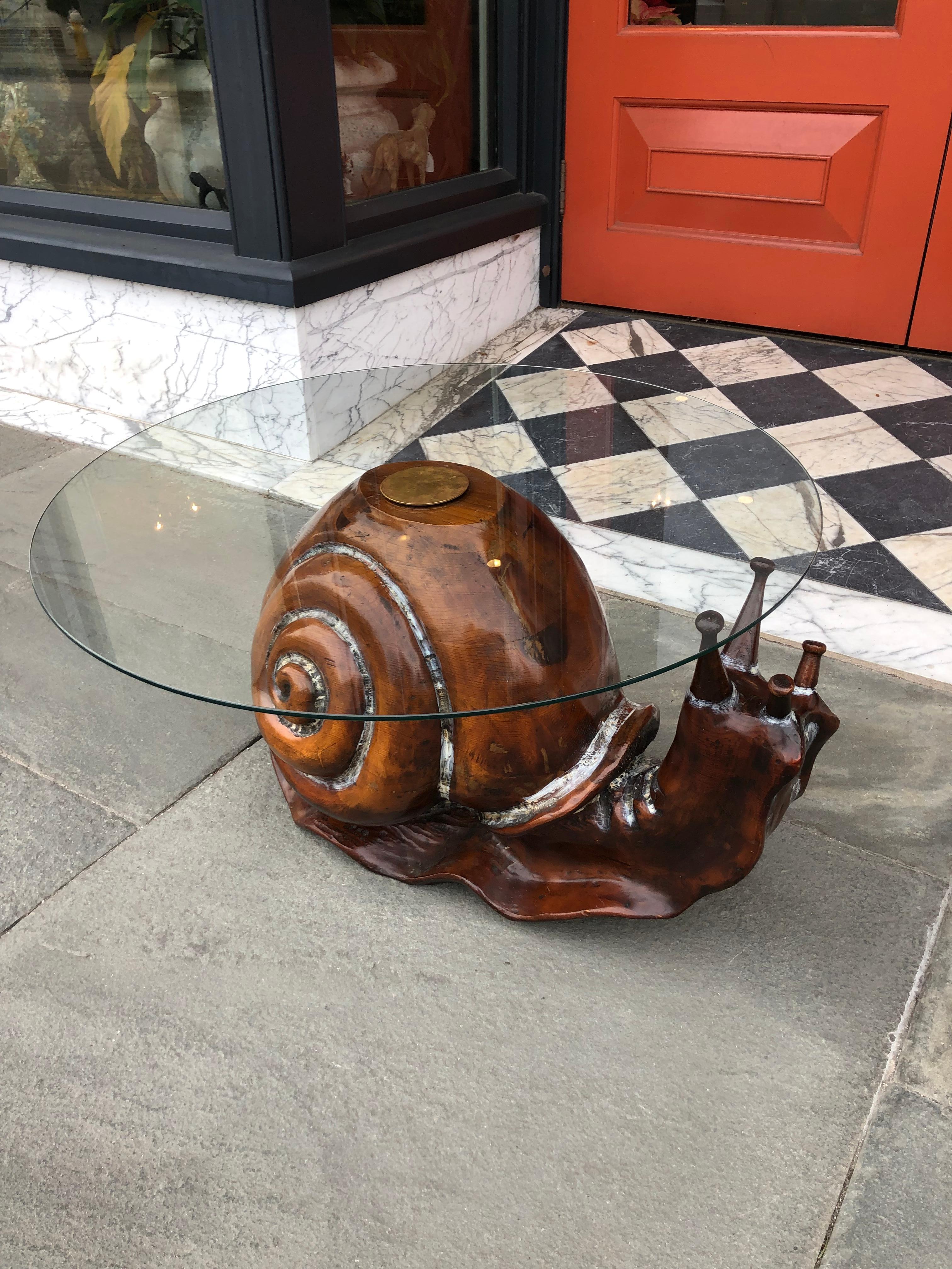 Carved wood snail with glass top, by Federico Armijo.  Great cocktail or side table. Accented with faded white paint, glass secured to top with brass fitting. 
  