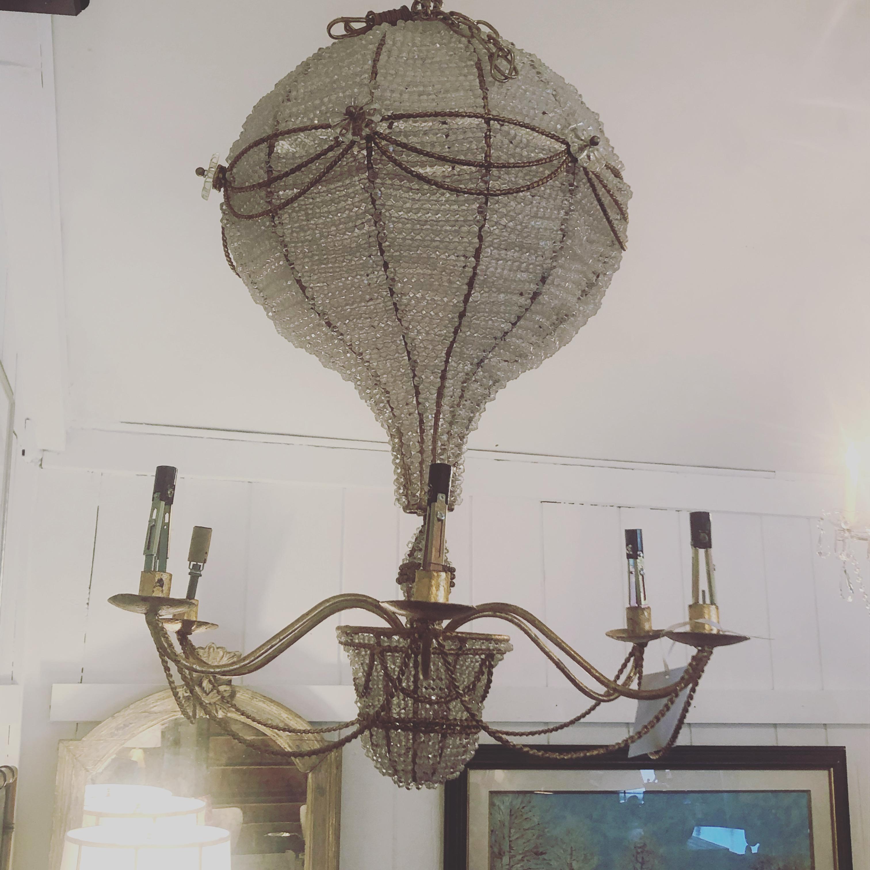 A magical vintage Italian or French chandelier in the shape of a hot air balloon having beaded crystal balloon top and decorative basket below. The braided brass armature is elegant and there are 6 candleabra arms. Pretty crystal florets are added
