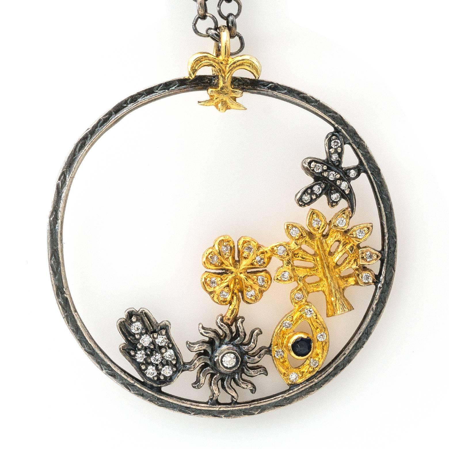 This whimsical pendant is a mixture of flora and the gold vermeil 'evil eye' with a black spinal.There is a four leaf clover in gold vermeil with diamonds and many more...suspended in a sterling silver ring oxidized. The chain is oxidized as