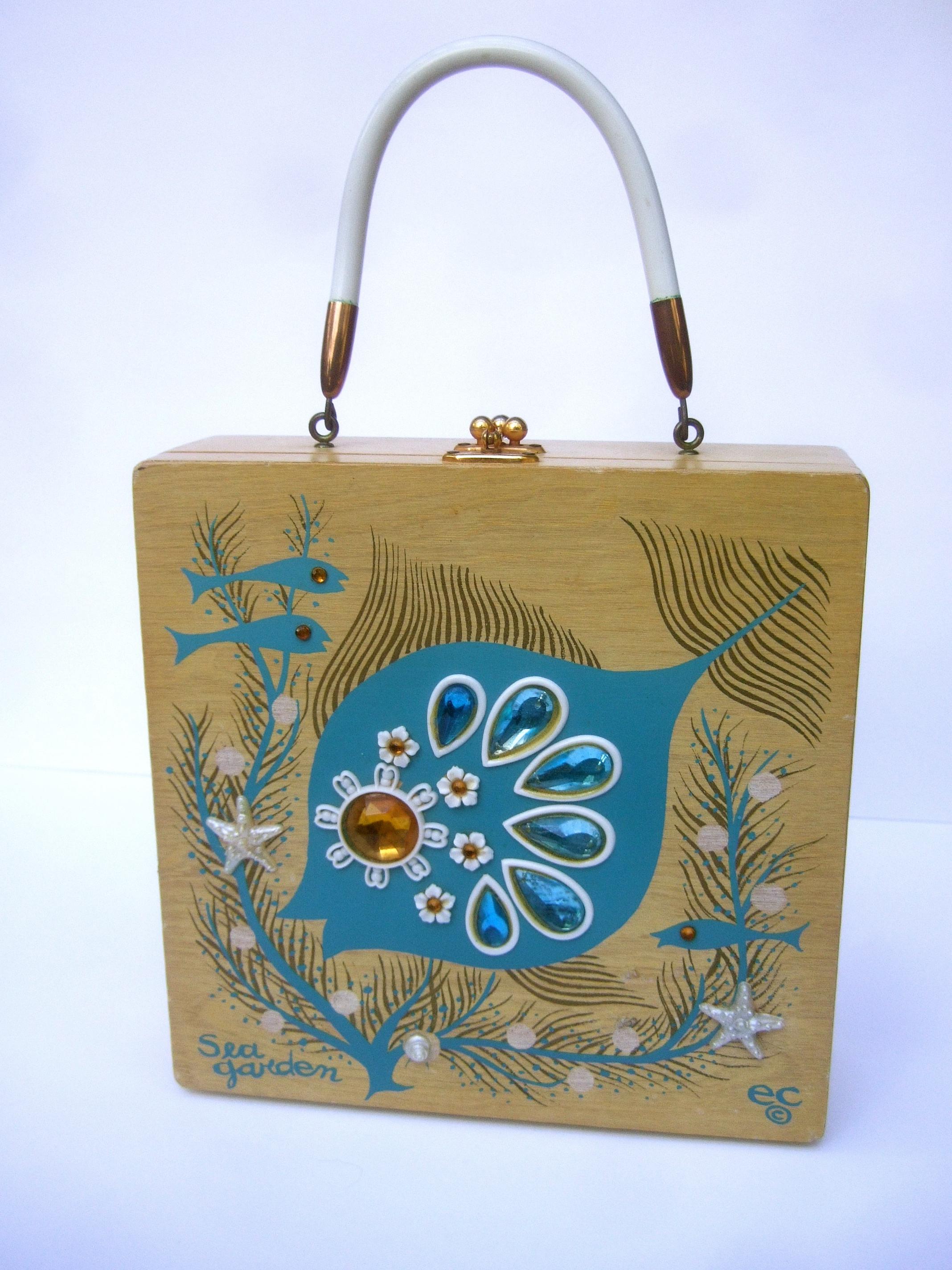 Whimsical Enid Collins blonde pine wood jeweled sea life themed box purse c 1960s
The charming retro wood box purse is decorated with an enamel stenciled 
underwater ocean scene illustrated with schools of fish & coral seaweed plants
on the front