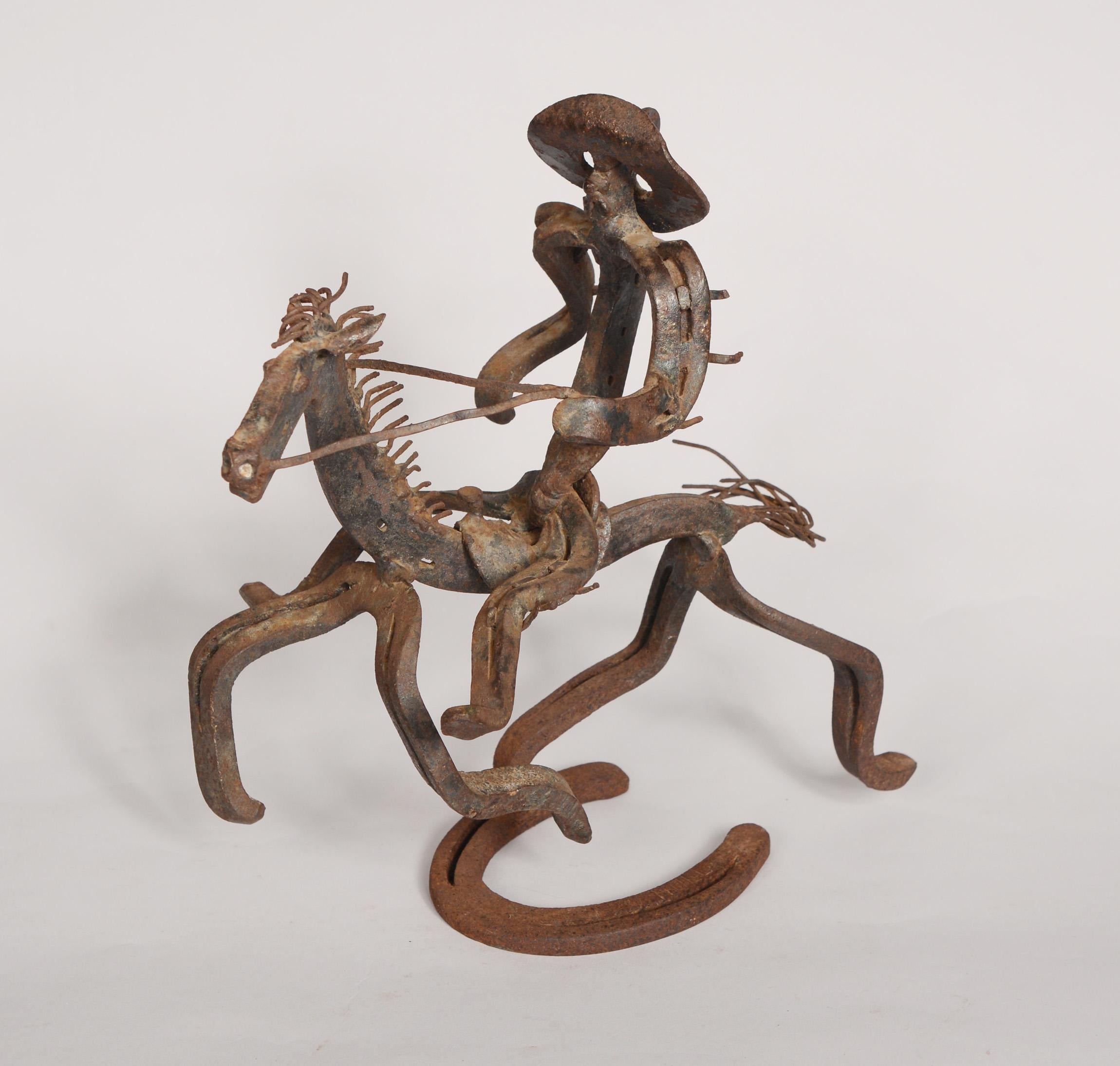 Folk art horseshoe sculpture of a cowboy on horseback. This sculpture uses blacksmith techniques with twisting and bending of the horseshoes making it very animated in appearance. The base is signed Hull.