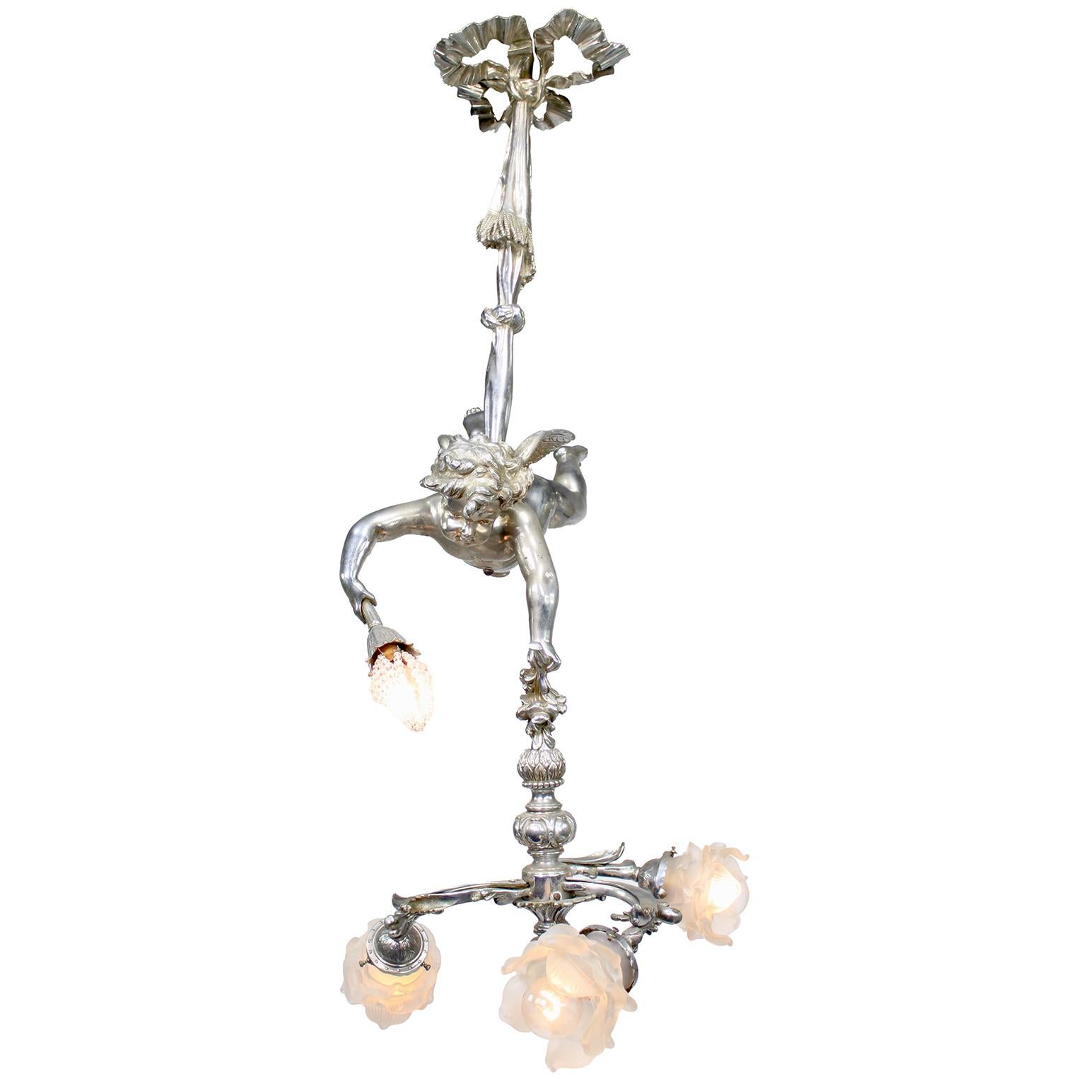 A Fine Whimsical French Belle Époque Silvered Bronze Four-Light Cherub Figural Hanging Chandelier. The charming cherub, scantily clad, hovers while suspended from a tied-draped tassel holding a beaded-glass light in his right hand, while the