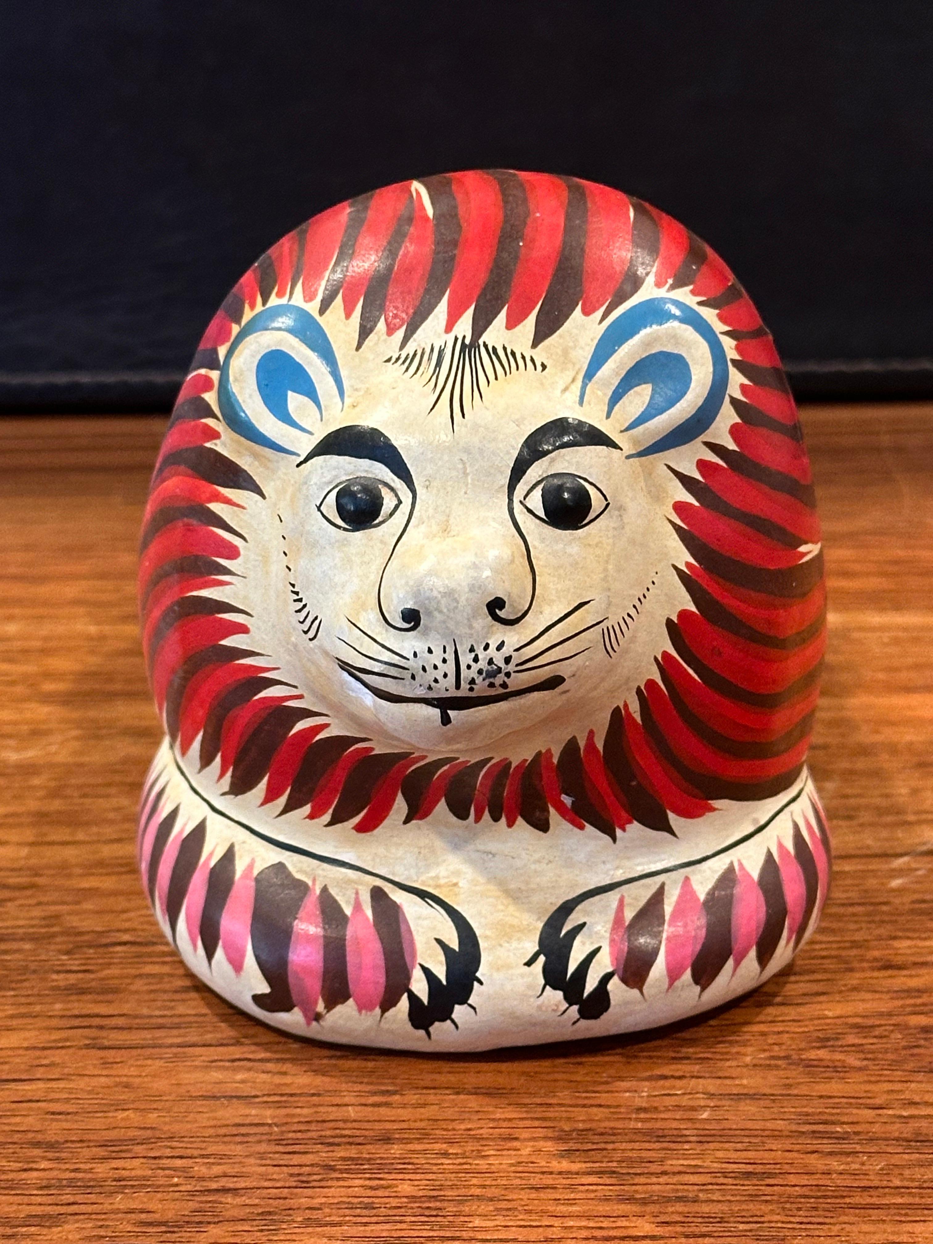 Whimsical hand painted ceramic lion sculpture in the style of Sergio Bustamante, circa 1980s. The piece is in good vintage condition and measures 4.5