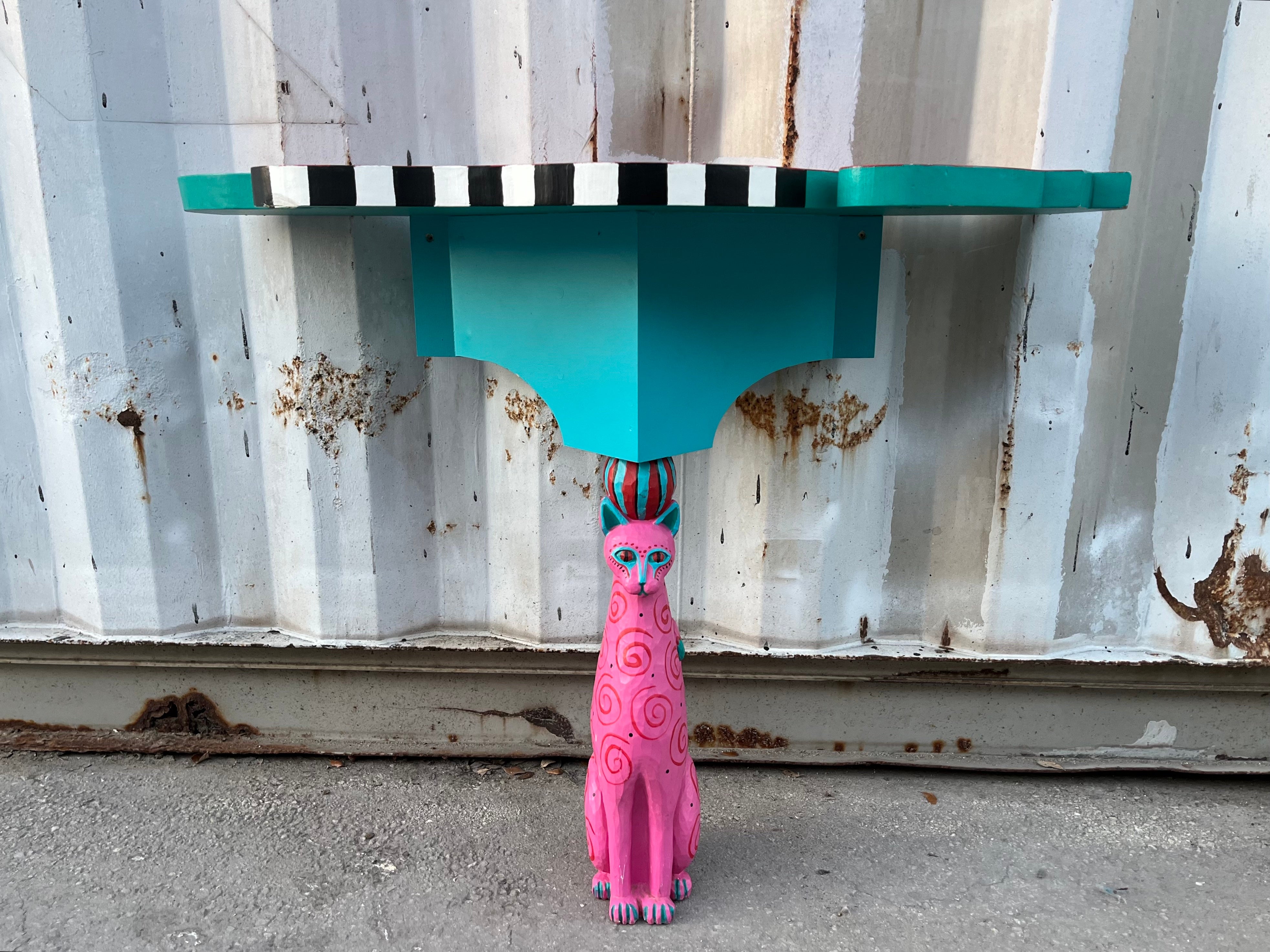 Consola / Mesa de Entrada Artesanal con Pedestal de Gato. Alrededor de finales de los 90 principios de los 2000 
Presenta un tablero de madera con intrincados bordes hechos a mano, acompañado de un soporte para gatos tallado a mano en colores