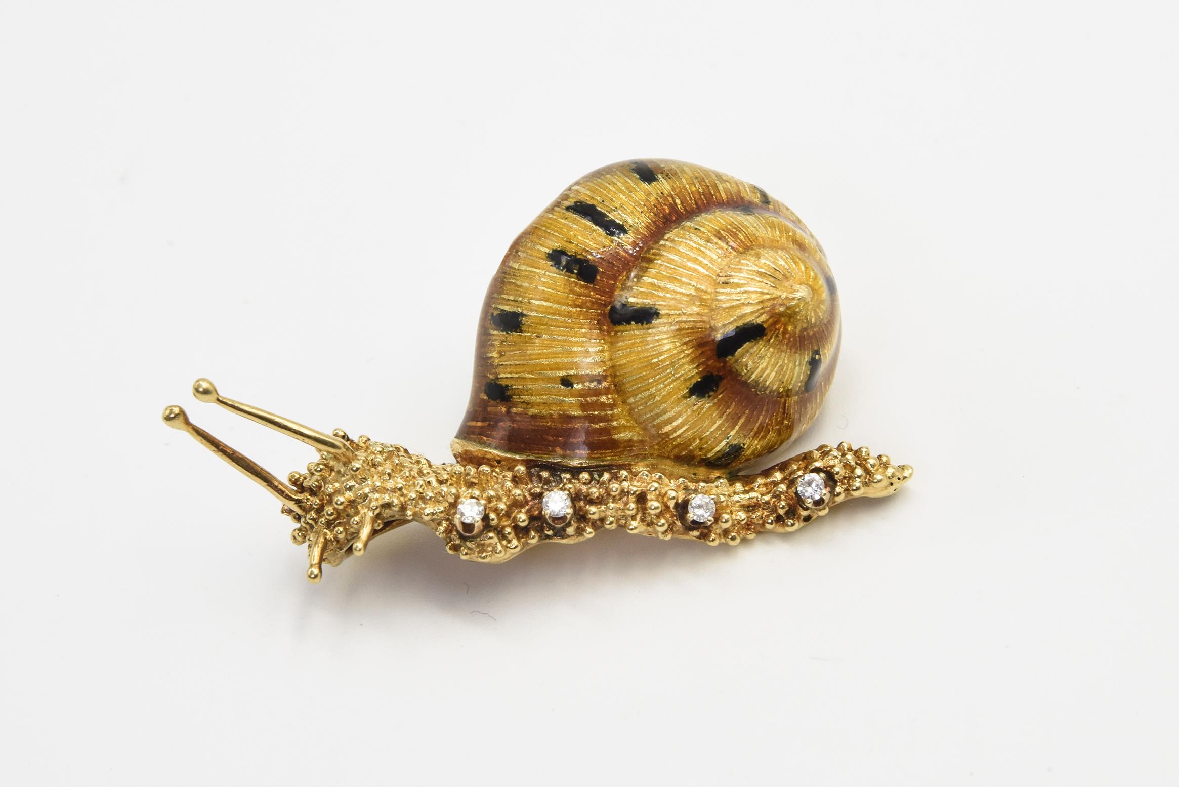 This exceptional realistic looking snail is amazing.  The golden enamel with black stripes shell is stunning.  The body of the snail is stylized gold that is three dimensional with four small diamonds to act as legs. It has two long antennae as well