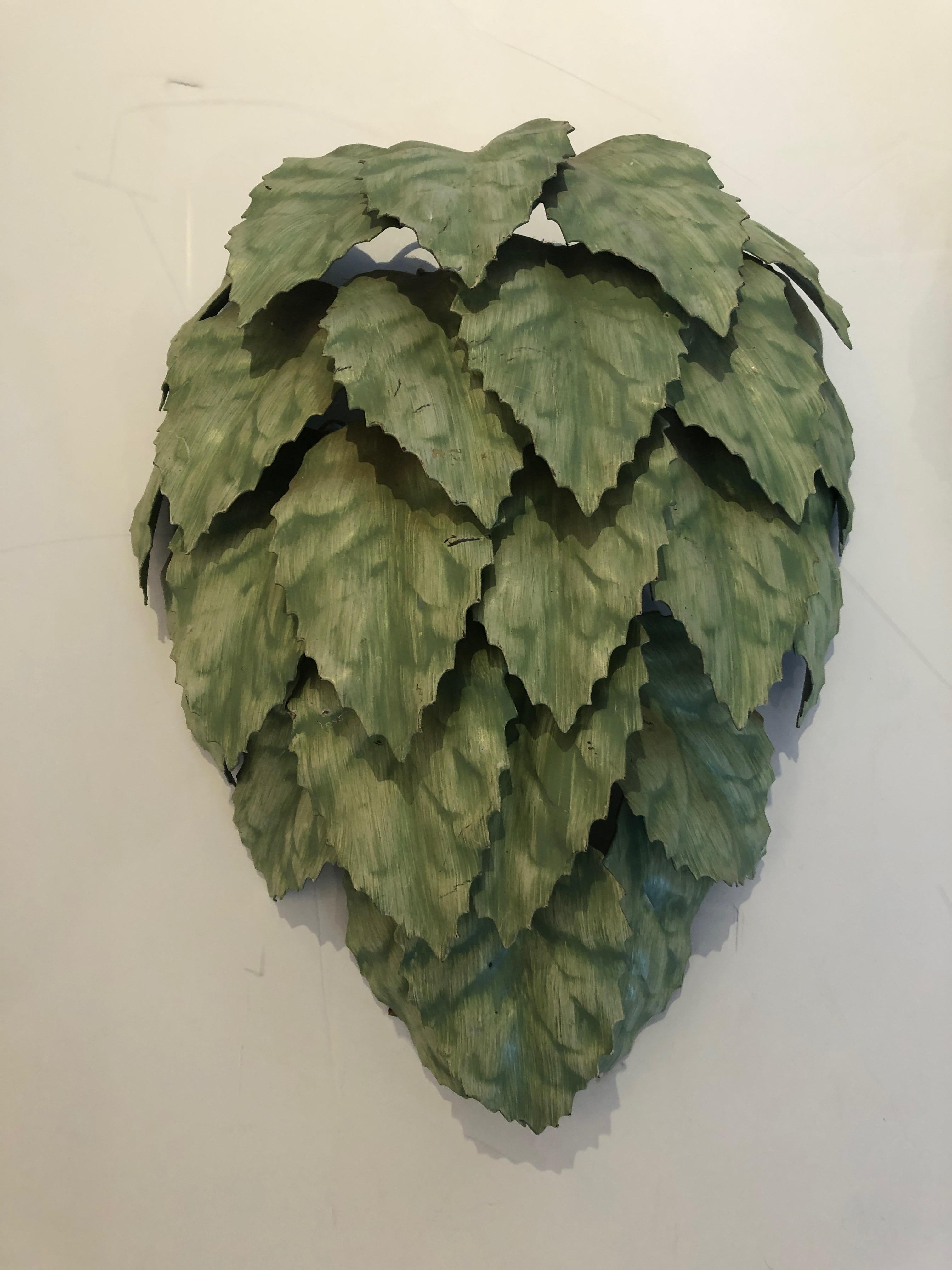 A fabulously whimsical pair of green painted tole sconces having meticulously layered rows of leaves that create wonderfully textured sculptural and decorative wall lights.
 