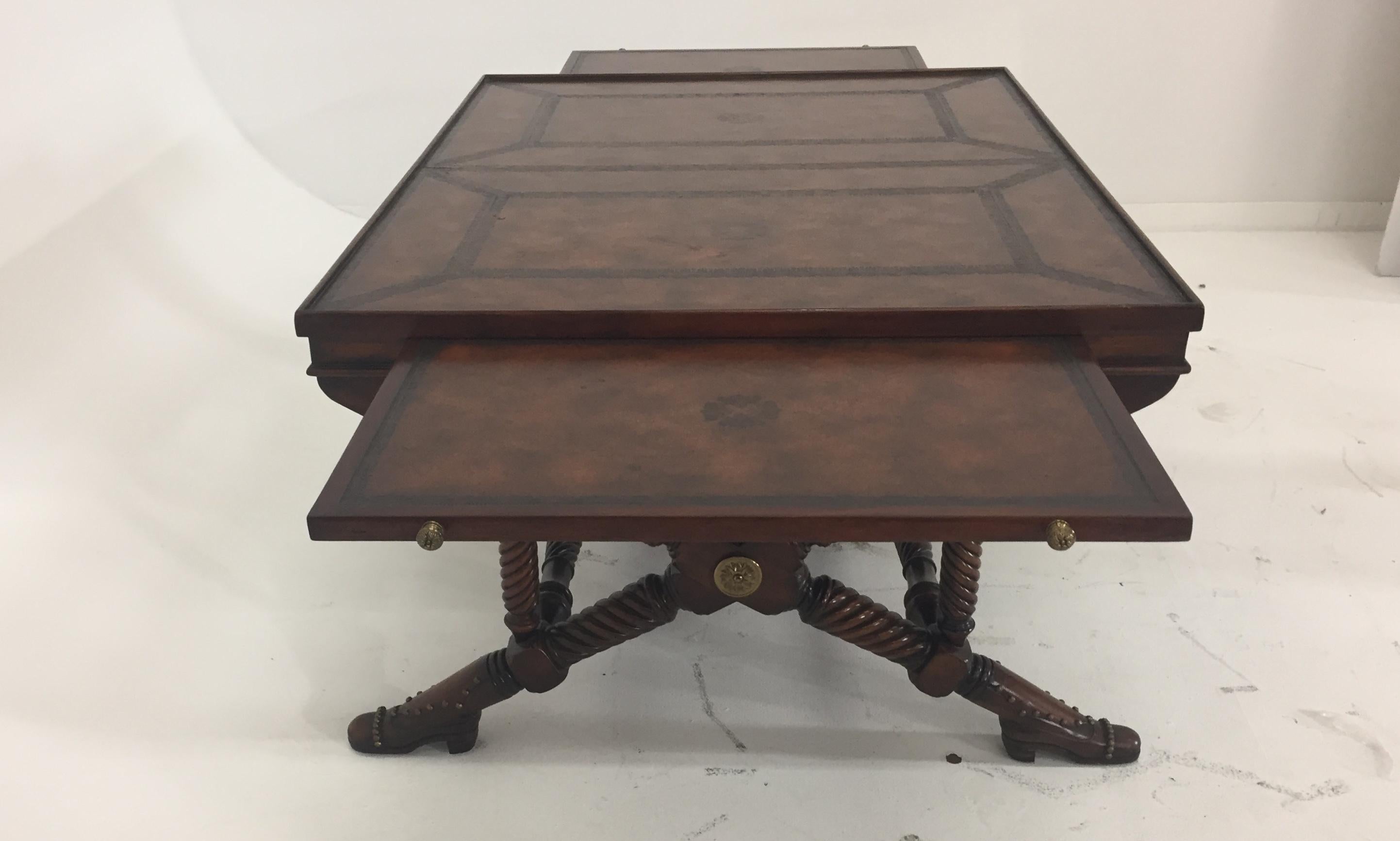 Rich and delightfully clever coffee table by Theodore Alexander having turned mahogany legs that end in adorable shoe feet with decorative nailheads. The top is leather and has two additional slides or trays for added surface area.
2 slides are 24
