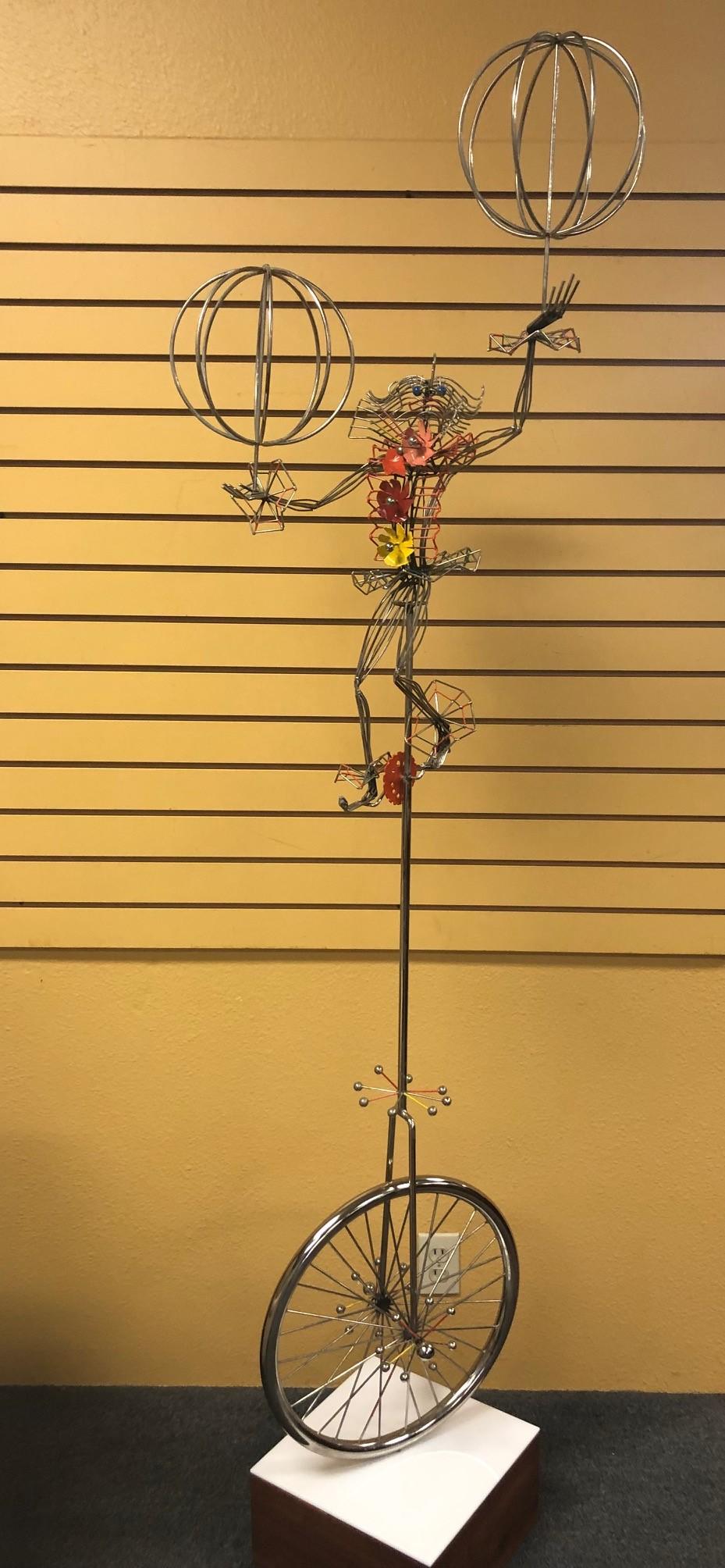 Whimsical metal kinetic sculpture of a clown on a unicycle with enamel highlights by noted sculptor Joseph Burlini, circa 1982.

Dimensions: 24