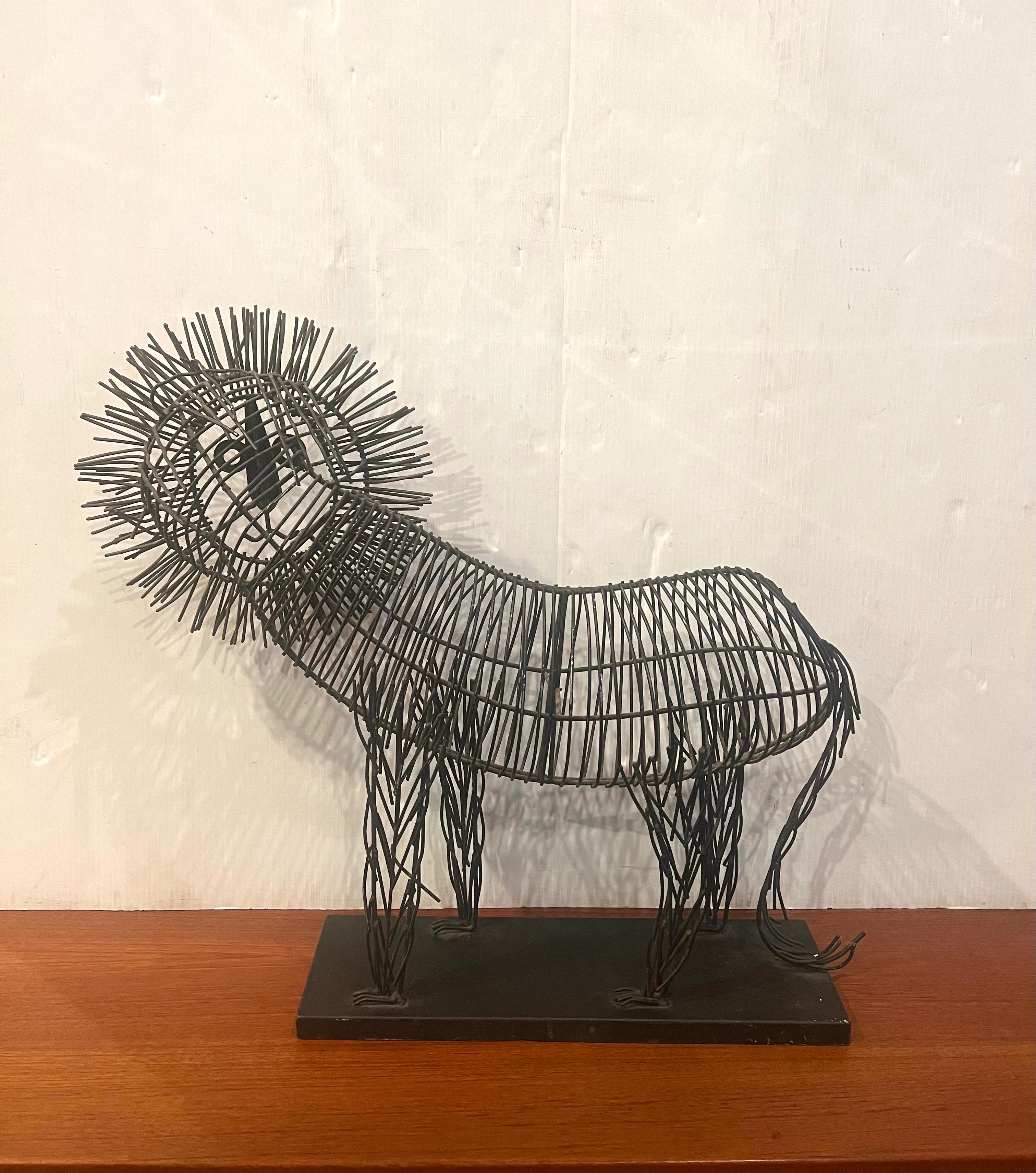 Metal wire large and rare size sculpture of a lion on a black metal base. The body is black metal wire and the mane is tinted in gold. In the style of C. Jere, circa 1990s.